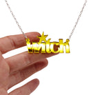 Witch necklace in yellow mirror shown hanging against a white background with my hand for size.