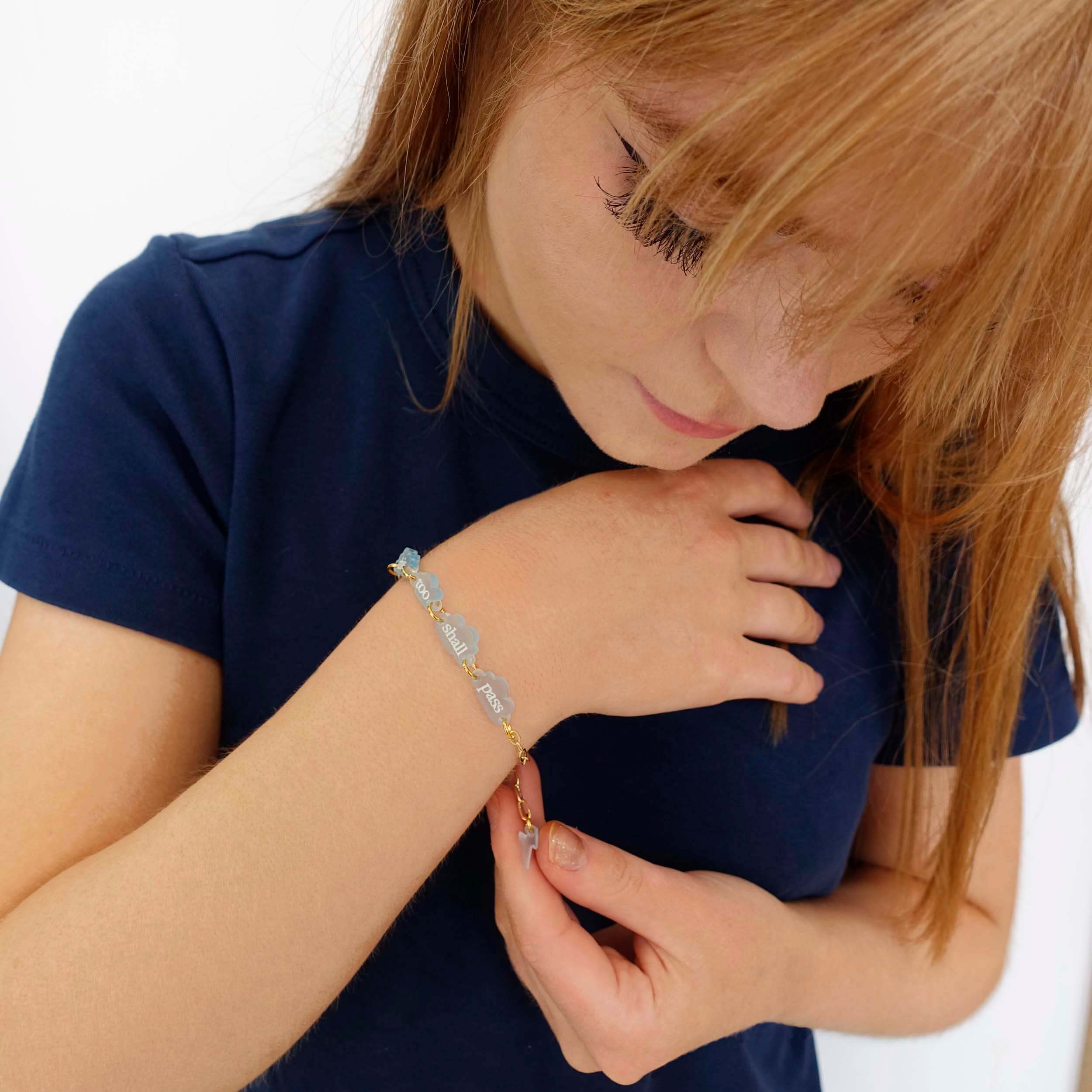 Eliza wears a This too shall pass floating clouds bracelet, designed by Sarah Day for Wear and Resist.
