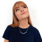 Eliza wears a This too shall pass floating clouds necklace, designed by Sarah Day for Wear and Resist.
