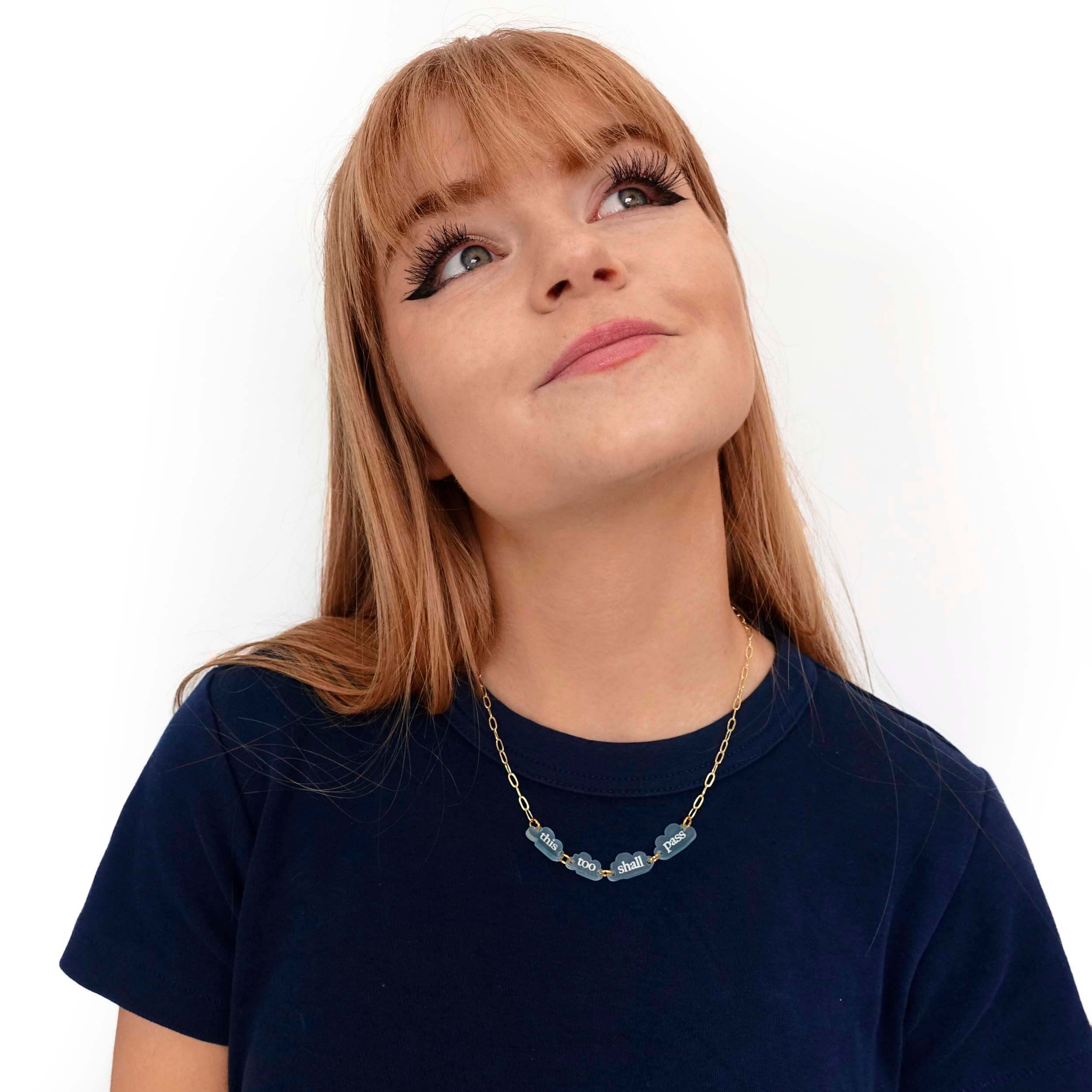 Eliza wears a This too shall pass floating clouds necklace, designed by Sarah Day for Wear and Resist.