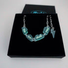 This too shall pass floating clouds necklace on a silver-plated paper-clip chain with lightning bolt charm, shown in a Wear and Resist gift box.