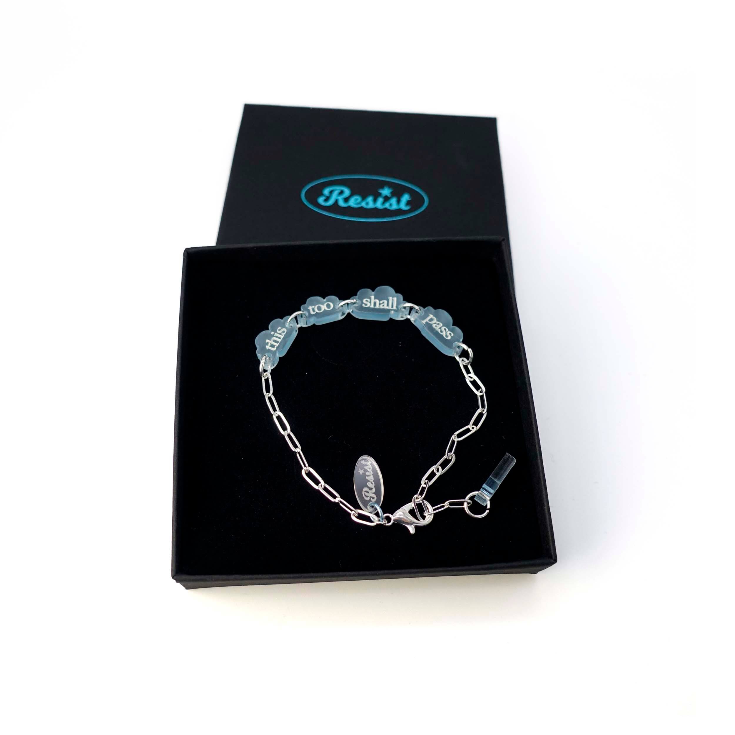 This too shall pass floating clouds bracelet on a silver-plated chain, shown in a Wear and Resist gift box.
