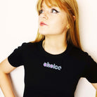 Model wears glitter black and purple pro-choice necklace, designed by Sarah Day for Wear and Resist.