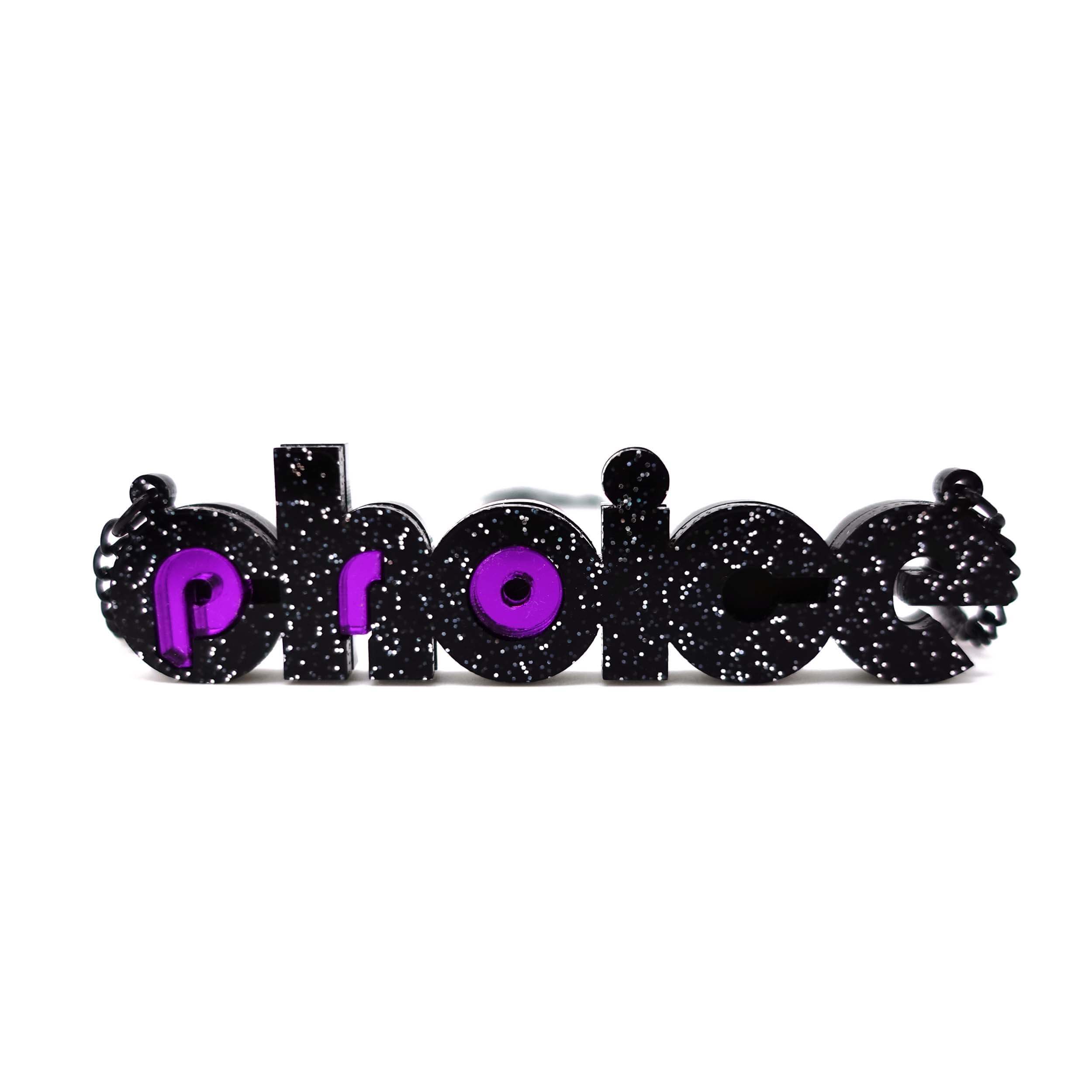 Black glitter and purple mirror Pro-choice necklace, shown standing on white background, designed by Sarah Day for Wear and Resist. £2 goes to Alliance for Choice who campaign  for Free, Safe and Legal abortions for anyone who needs them.
