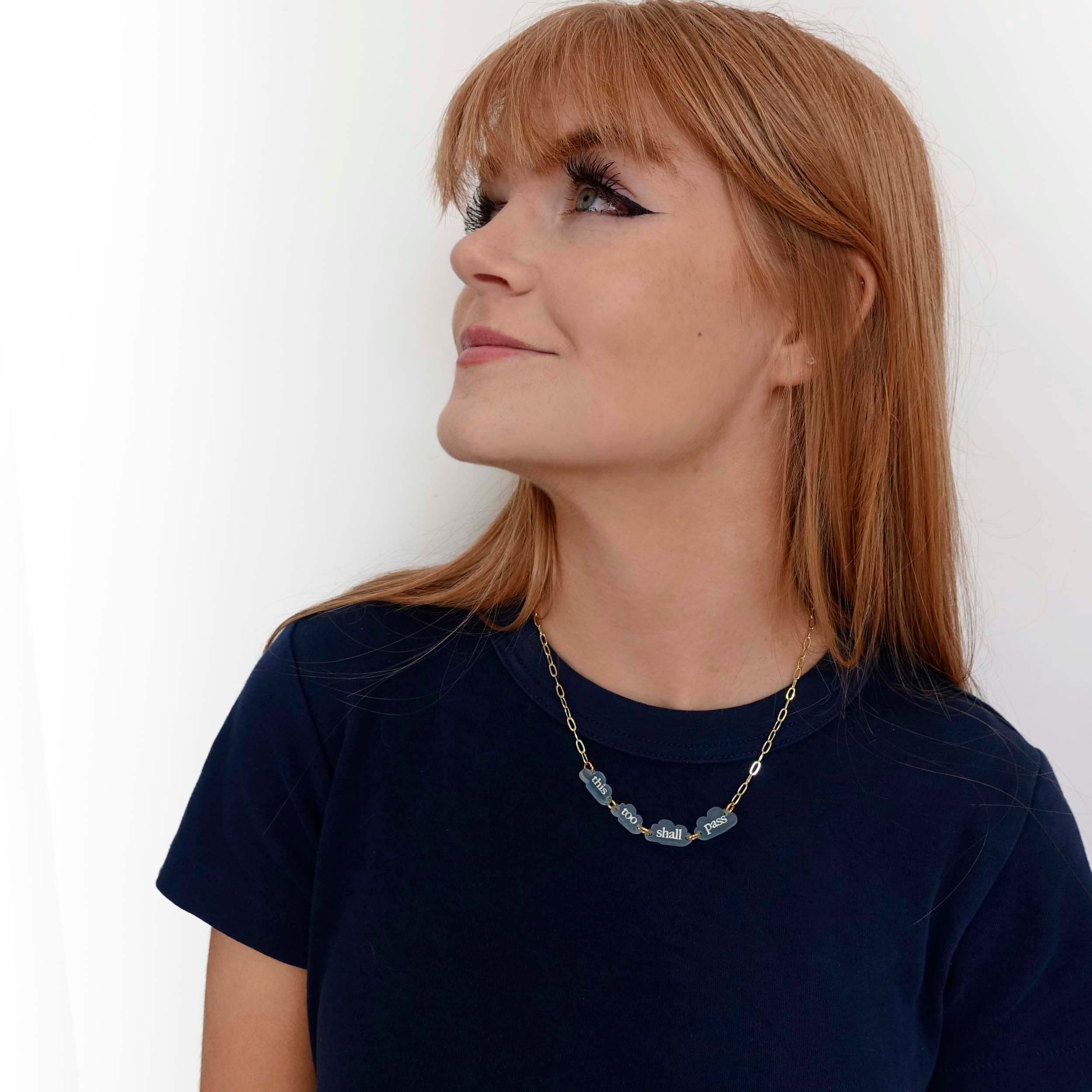 Eliza wears a This too shall pass floating clouds necklace, designed by Sarah Day for Wear and Resist.  Shown here on a gold paperclip chain.