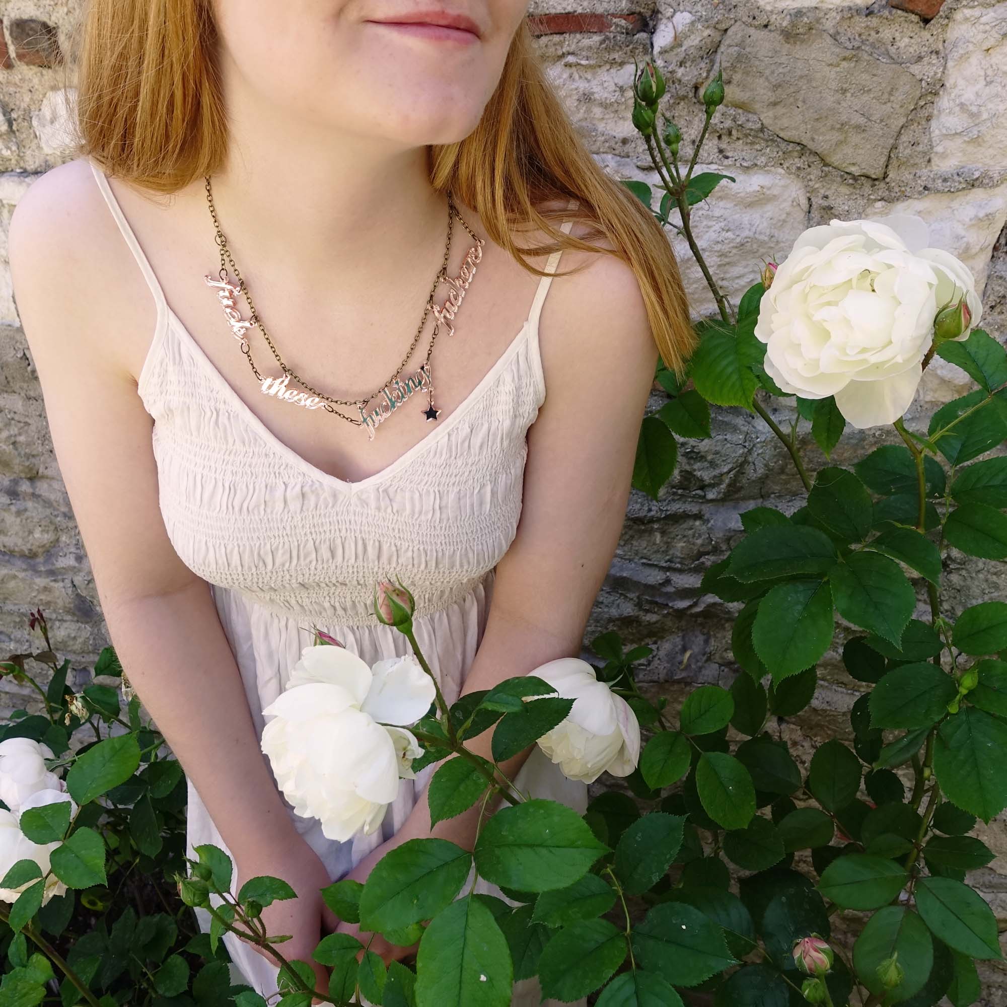 Eliza in the roses wearing a F*ck these F*cking F*ckers necklace in rose gold mirror.
