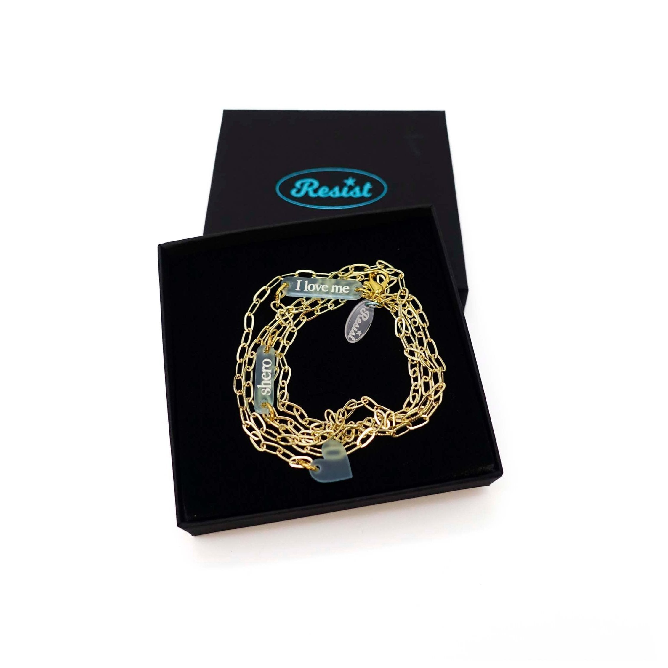 The Have a Word with Yourself design on a gold-plated paperclip chain, with the words 'I love me' and 'shero etched in glow-in-the-dark pigment and finished with a heart charm. Shown in a Wear and Resist gift box.