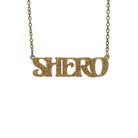 Gold glitter Shero necklace hanging against a white background.