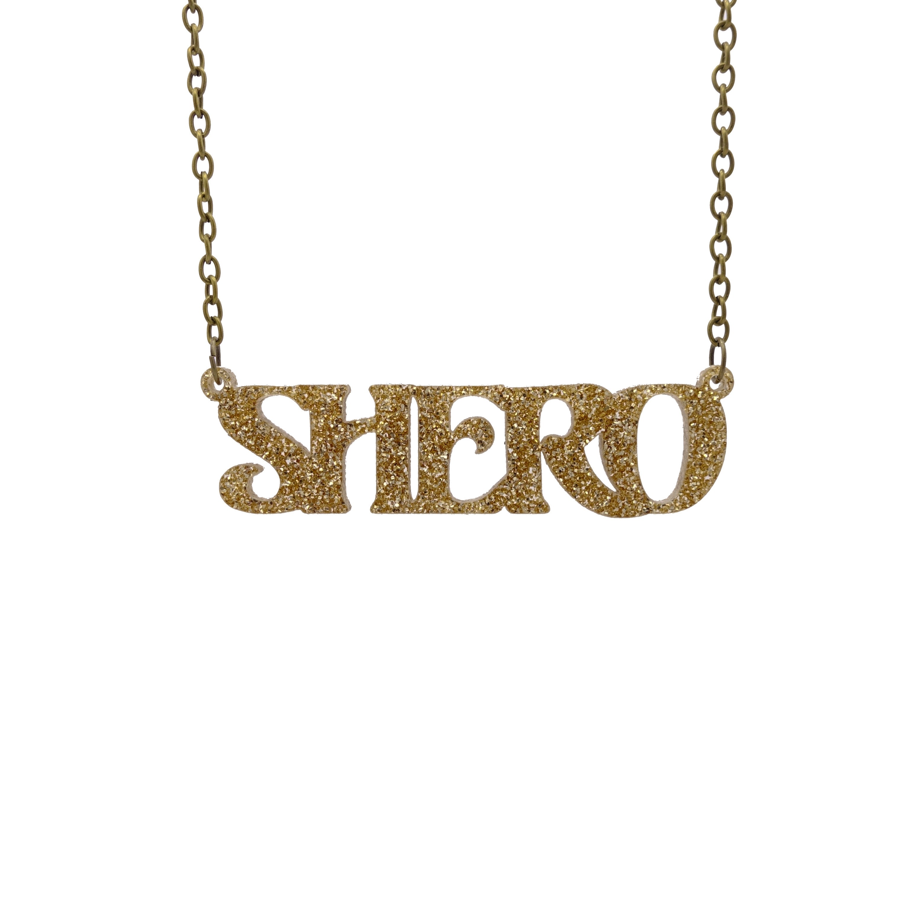 Gold glitter Shero necklace hanging against a white background.