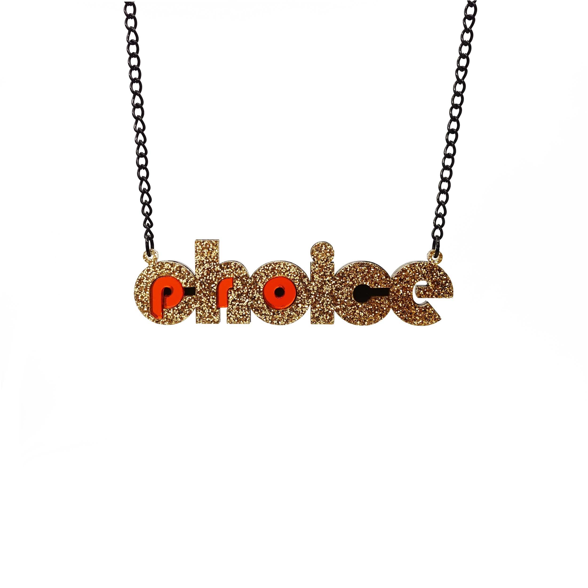 Gold glitter and flame mirror Pro-choice necklace, shown hanging on black necklace, designed by Sarah Day for Wear and Resist. £2 goes to Alliance for Choice who campaign  for Free, Safe and Legal abortions for anyone who needs them.