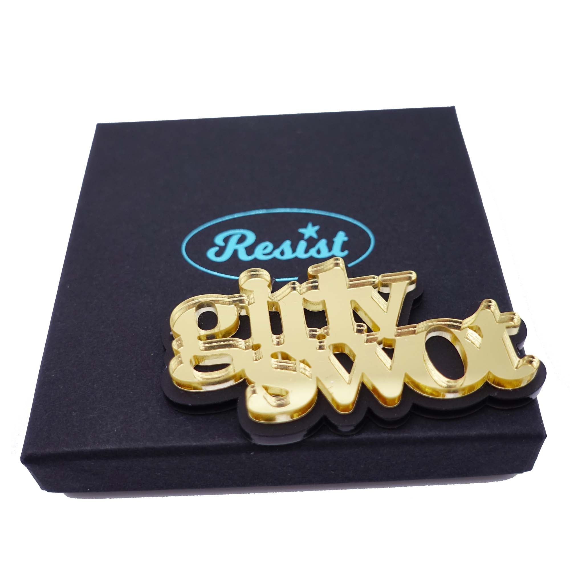 Girly swot brooch in gold mirror shown on a Wear and Resist gift box. Girly Swots Unite!