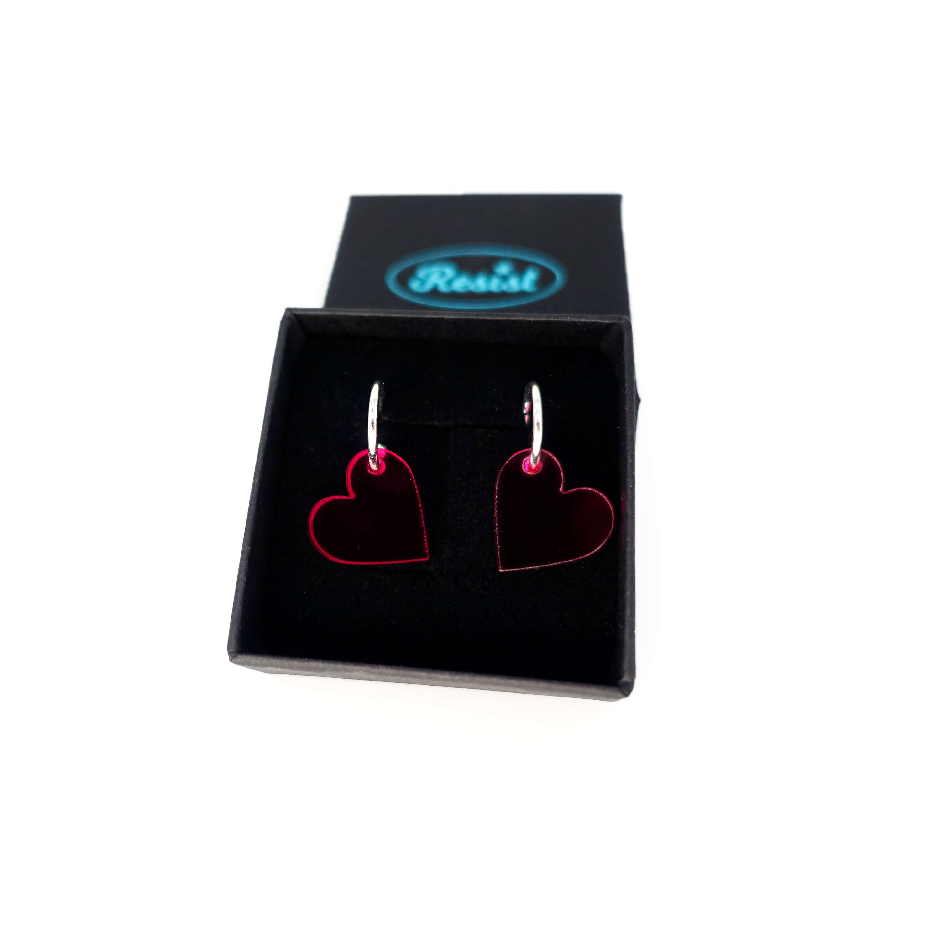 Neon pink simple heart hoop earrings on silver-plated hoops. Shown in a small Wear and Resist gift box.