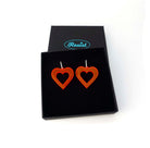 Big heart hoops in hot red on silver hoops, shown in a Wear and Resist gift box.
