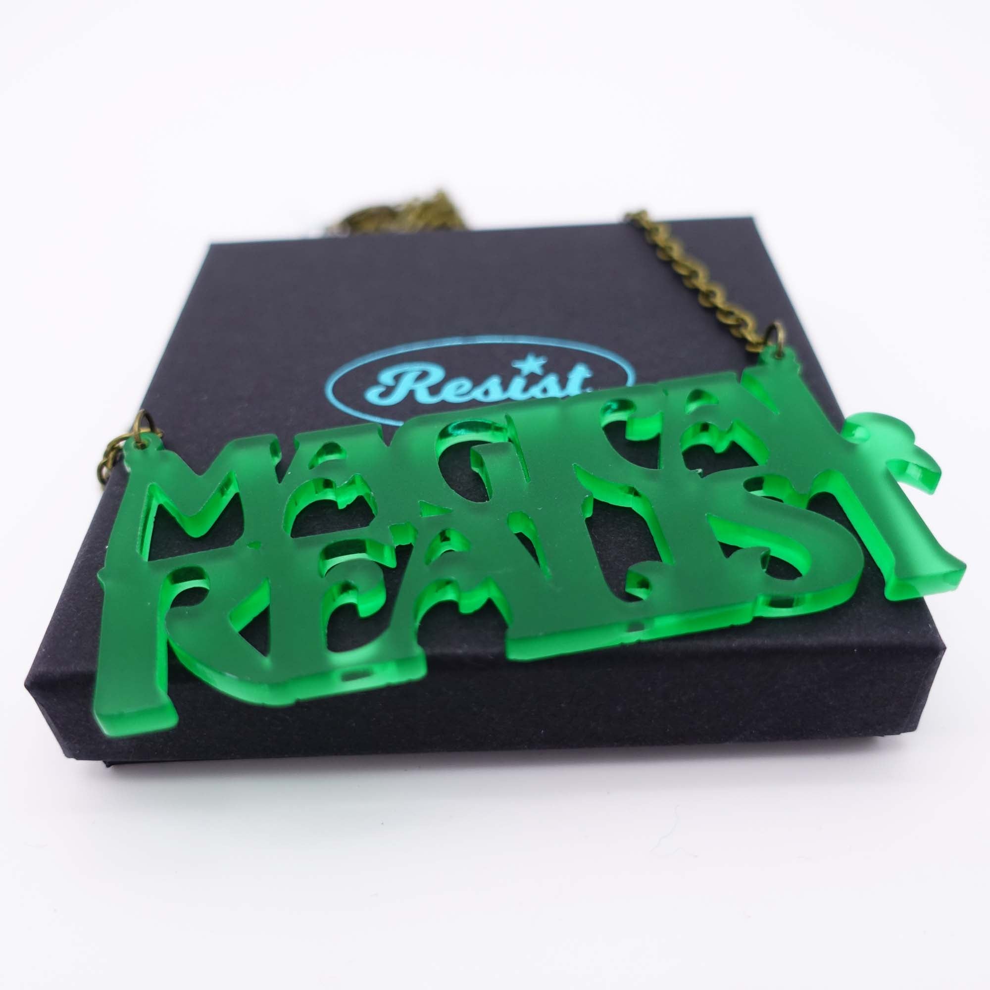 A close up of a leaf frost Magical Realist necklace, shown on a Wear and Resist gift box.