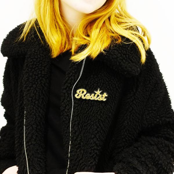 model wearing gold glitter script resist brooch