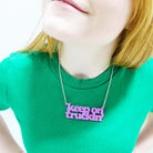 Eliza wears a Keep on Truckin' necklace in bubblegum pink.
