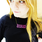 Eliza wears a Keep on Truckin' necklace in maroon.