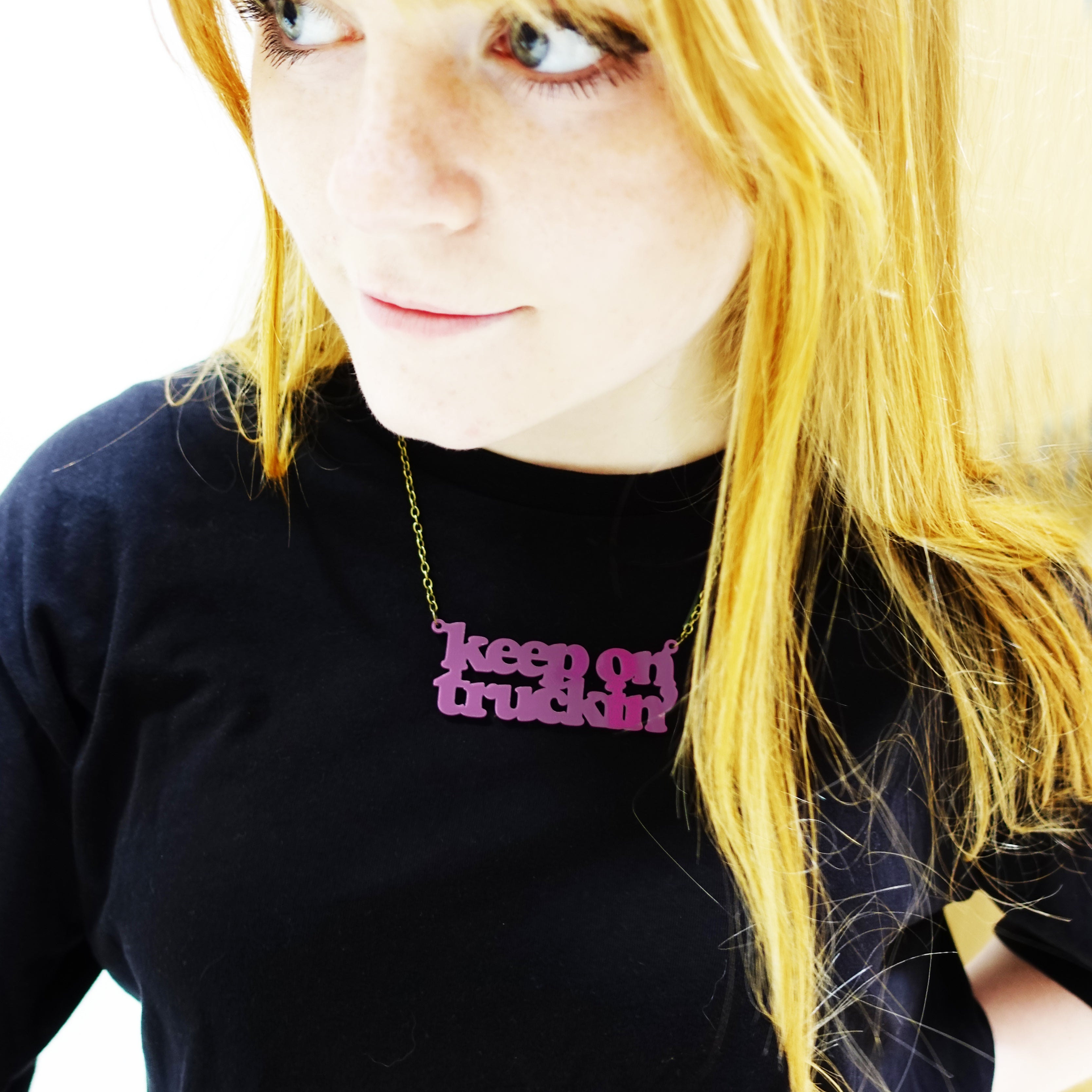 Eliza wears a Keep on Truckin' necklace in maroon.