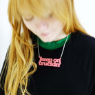 Eliza wears a Keep on Truckin' necklace in sunset pink.