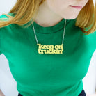 Eliza wears a Keep on Truckin' necklace in lemon drop.