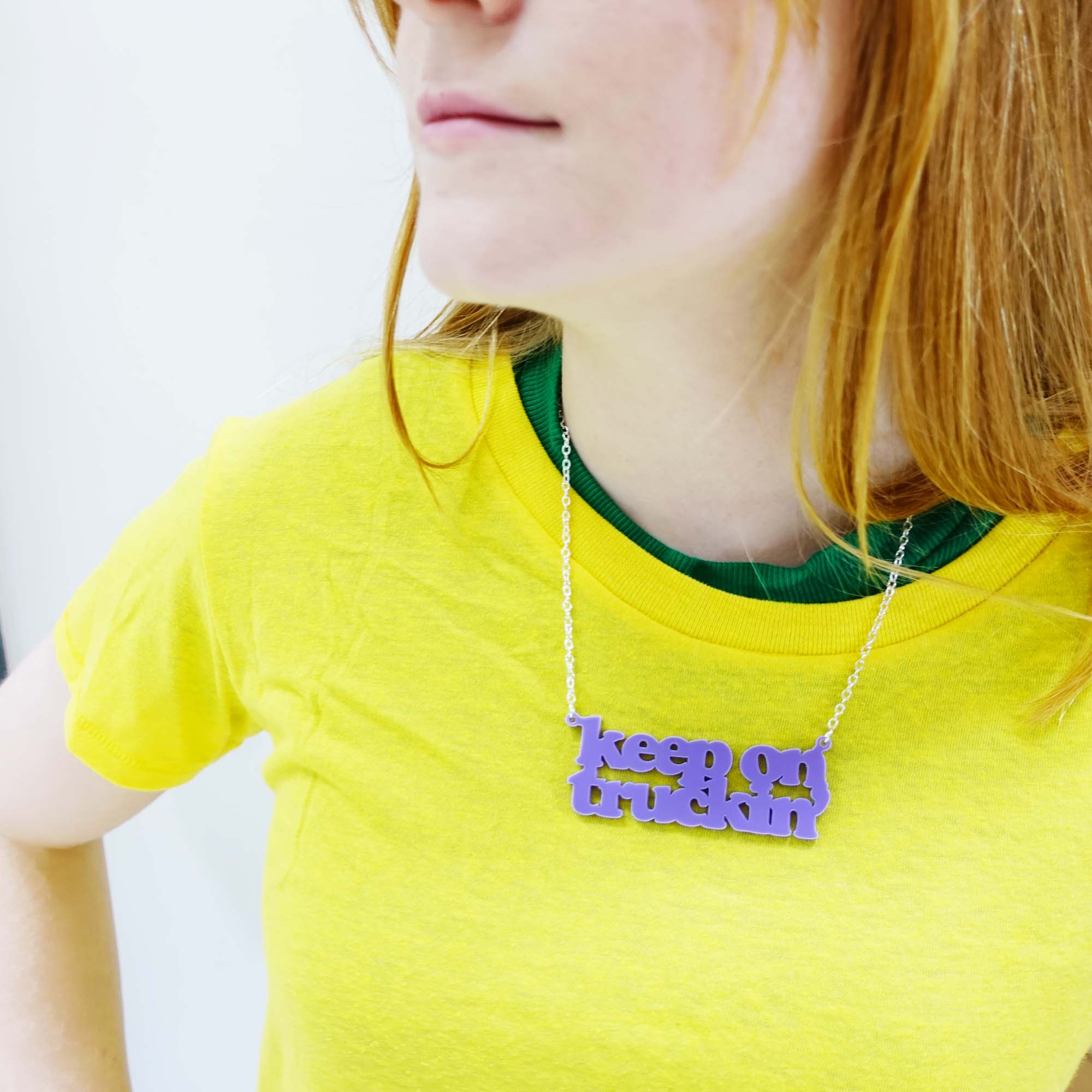 Eliza wears a Keep on Truckin' necklace in parma violet.