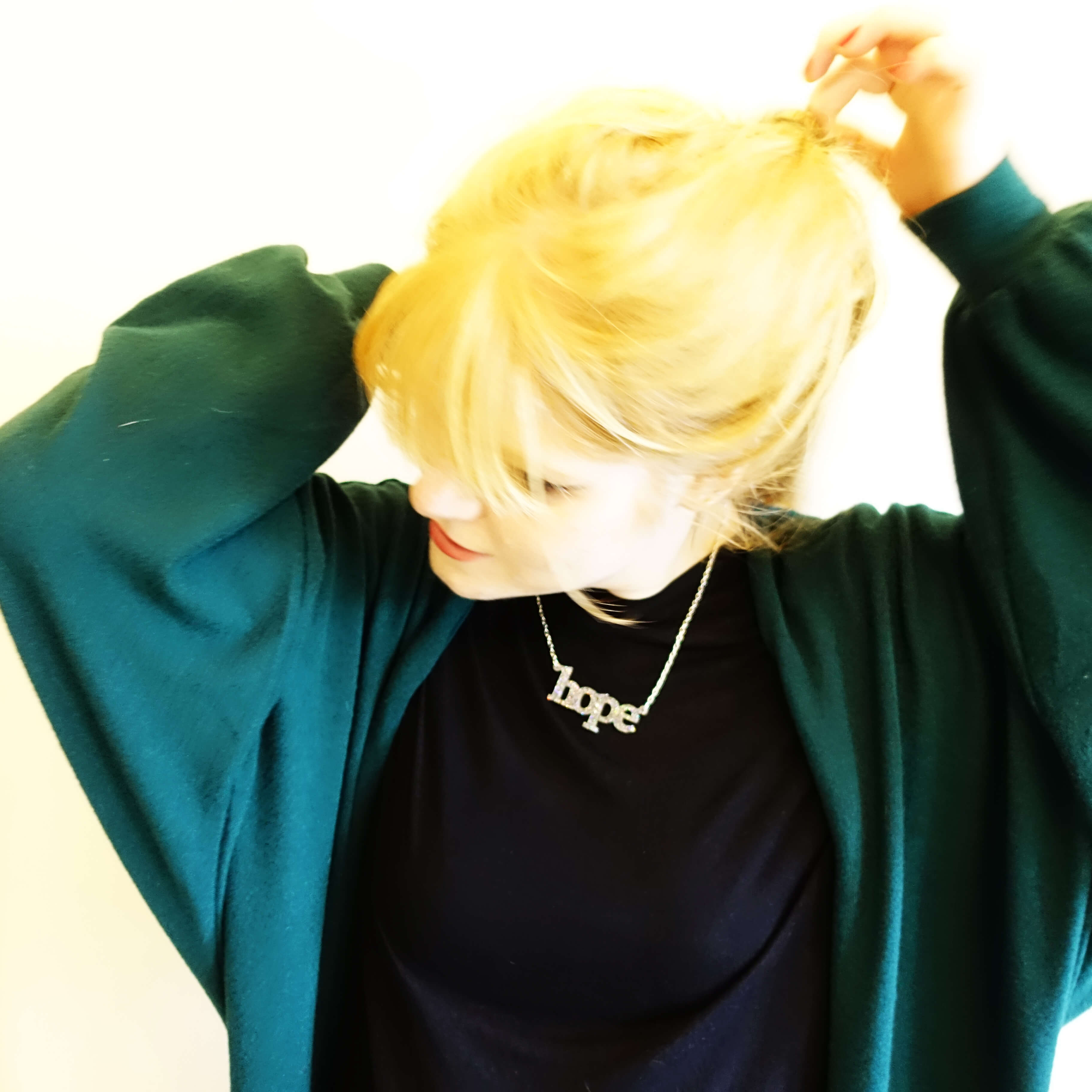 Eliza wears a silver glitter Hope necklace, designed by Sarah Day for Wear and Resist.