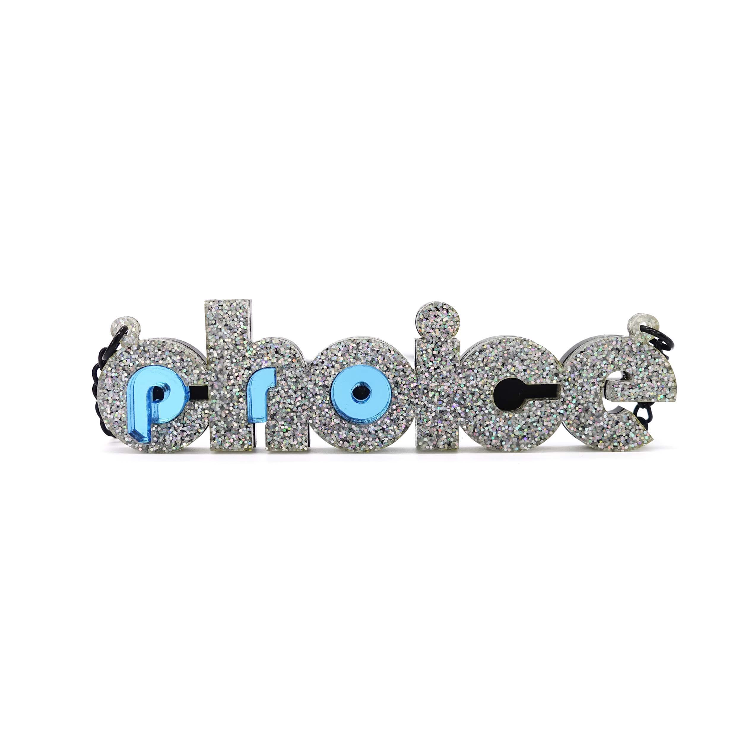 Iridescent silver glitter and sky blue mirror Pro-choice necklace shown standing on white background, designed by Sarah Day for Wear and Resist. £2 goes to Alliance for Choice who campaign  for Free, Safe and Legal abortions for anyone who needs them.