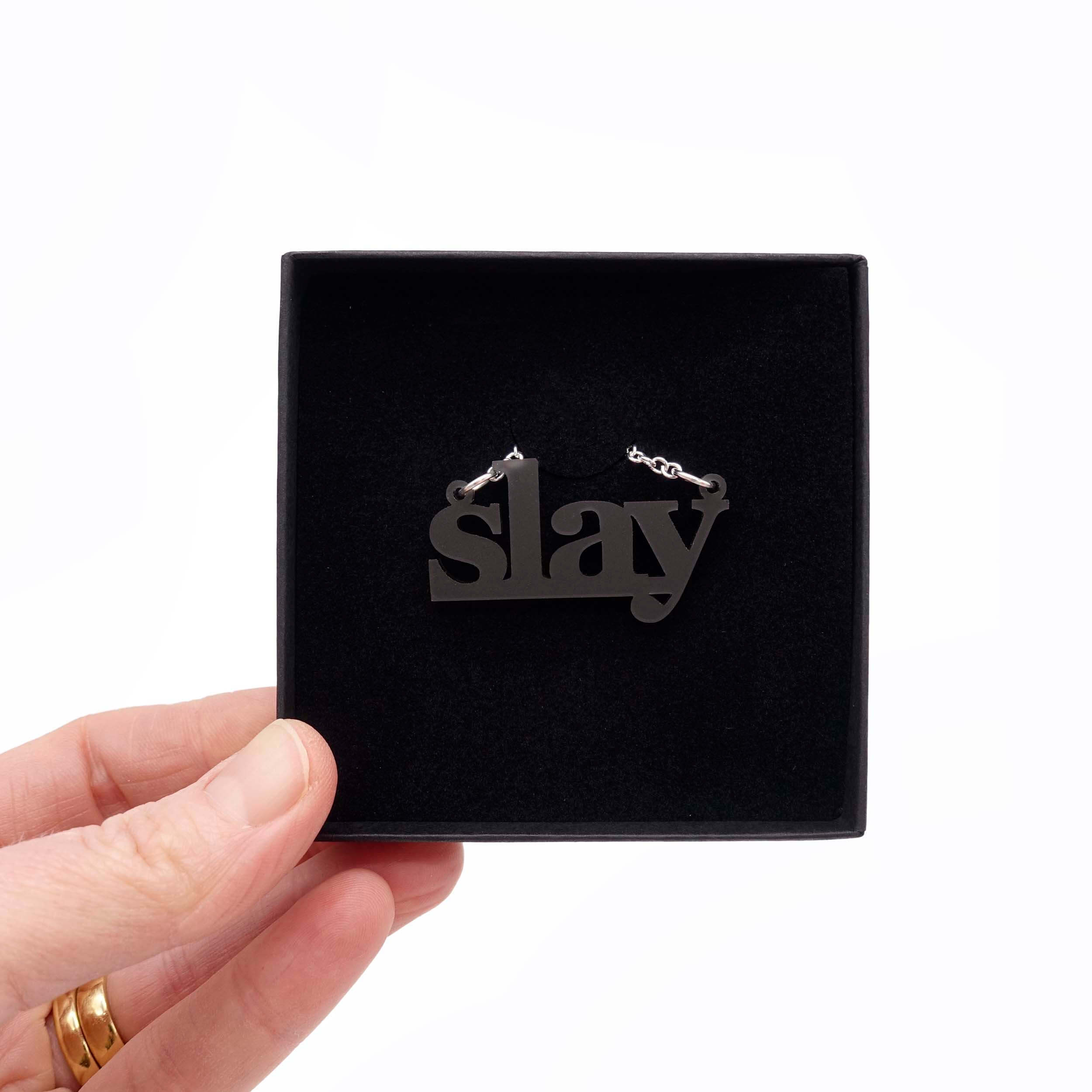 Slate frost Slay necklace shown being held up in a gift box.