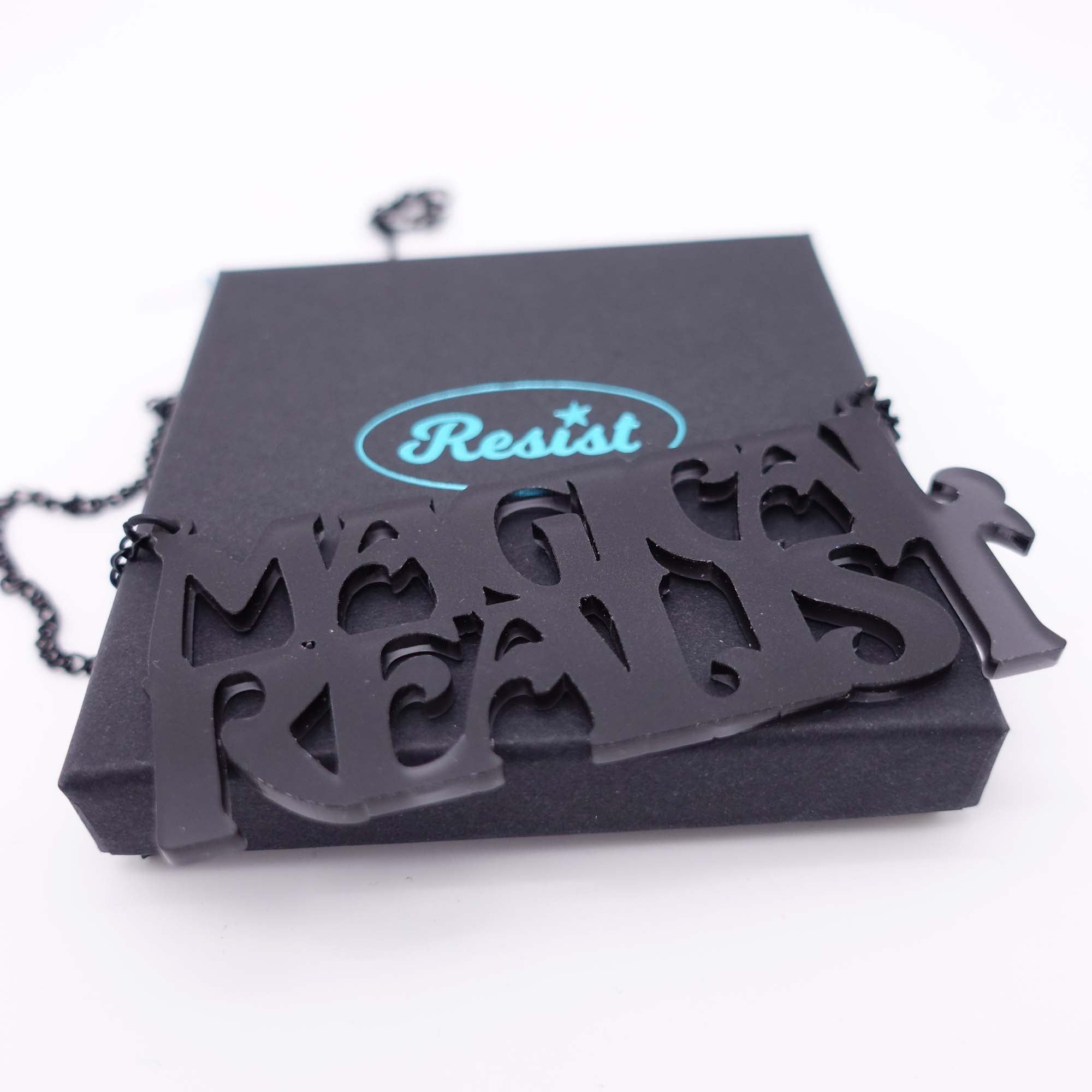 A close up of a slate frost Magical Realist necklace, shown on a Wear and Resist gift box.