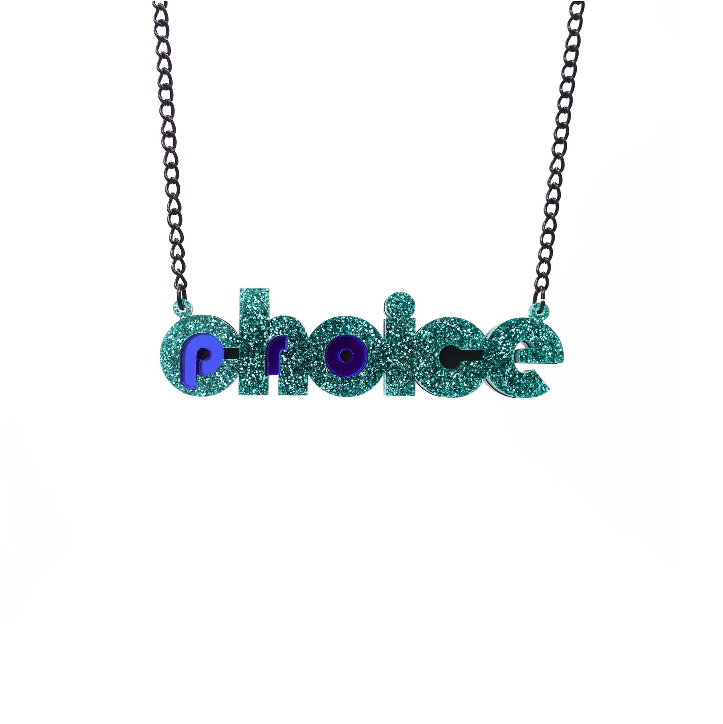 Teal glitter and indigo mirror Pro-choice necklace, shown hanging on black chain, designed by Sarah Day for Wear and Resist. £2 goes to Alliance for Choice who campaign  for Free, Safe and Legal abortions for anyone who needs them.