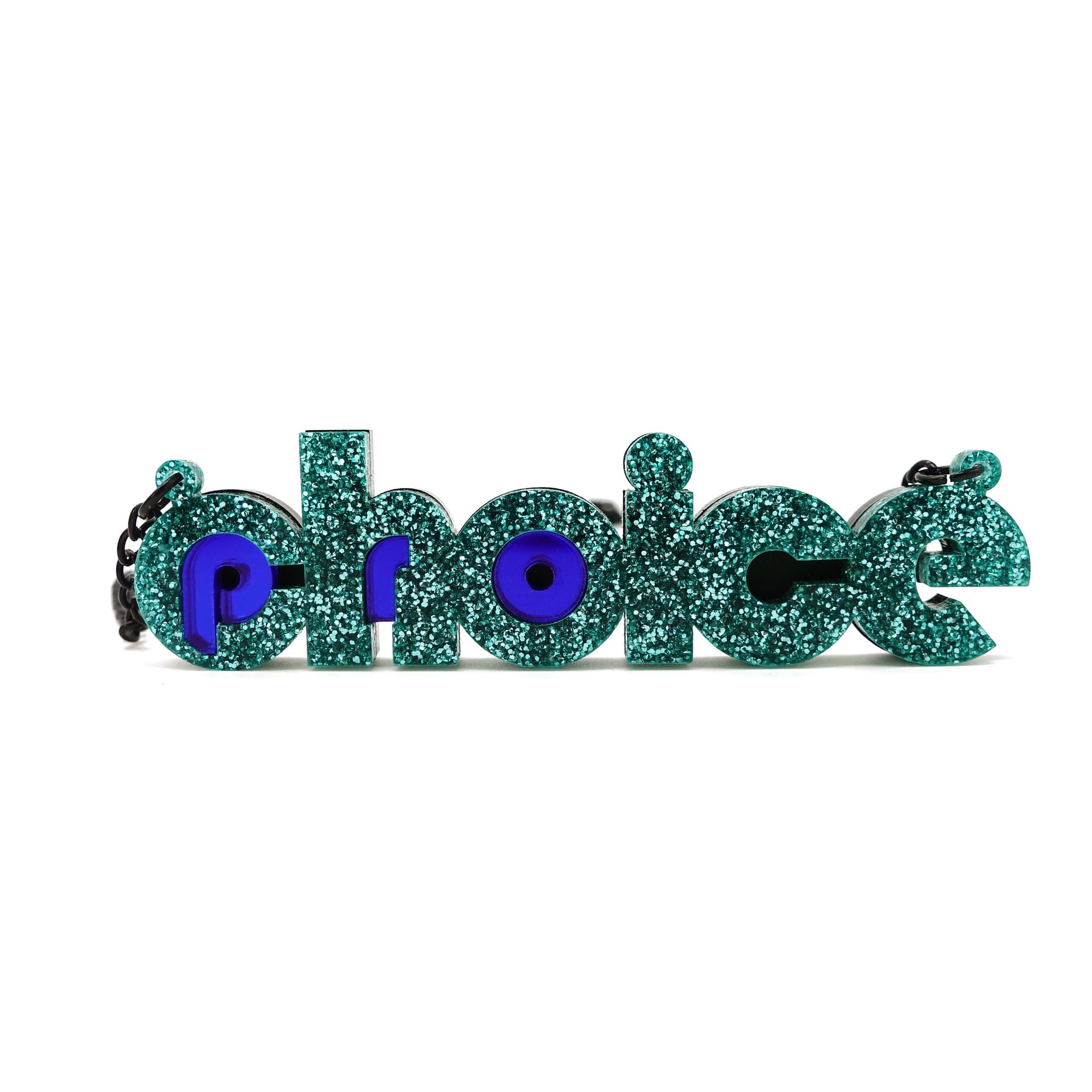 Teal glitter and indigo mirror Pro-choice necklace, shown standing on white background, designed by Sarah Day for Wear and Resist. £2 goes to Alliance for Choice who campaign  for Free, Safe and Legal abortions for anyone who needs them.