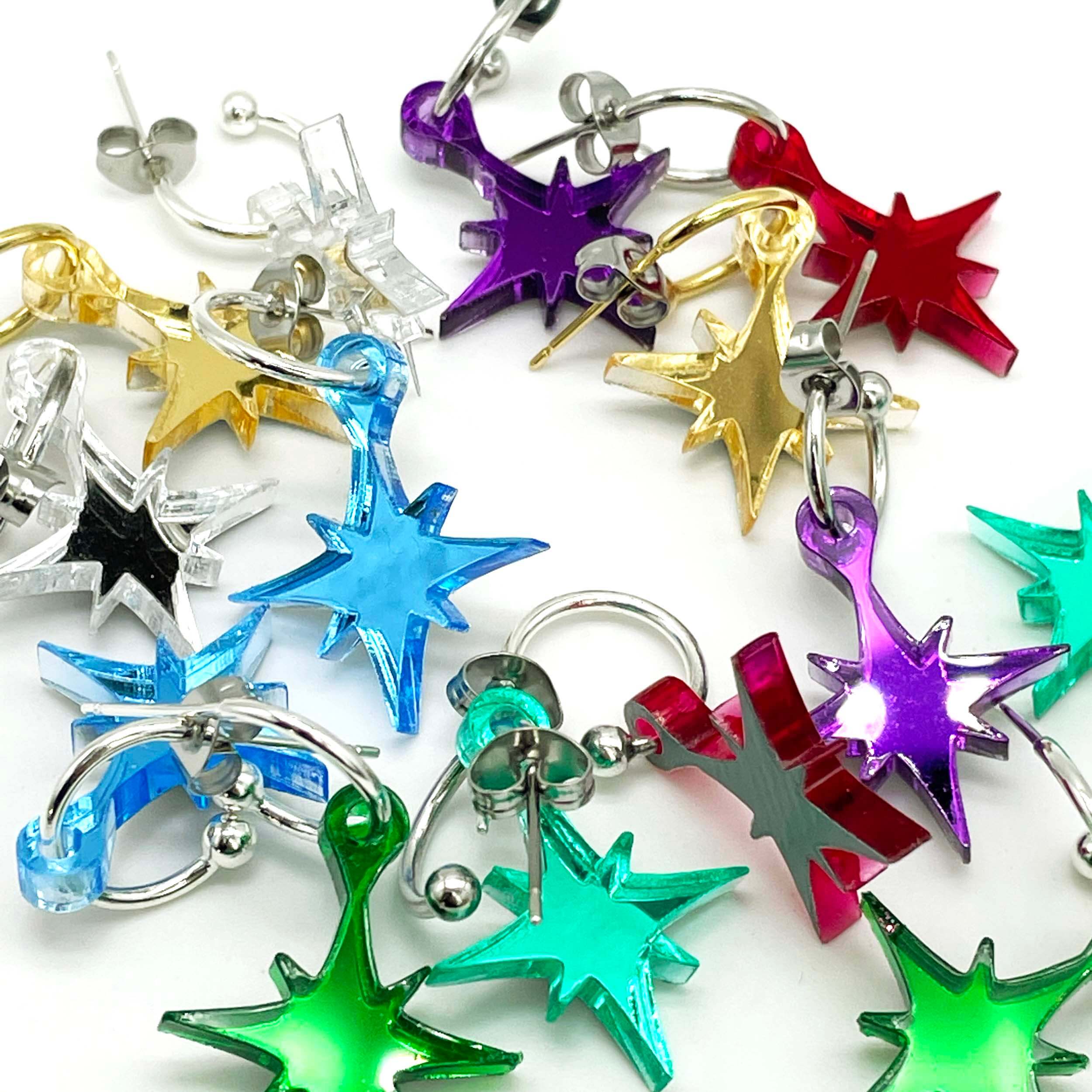 A group shot of different colours of vintage star earrings on gold and silver hoops.