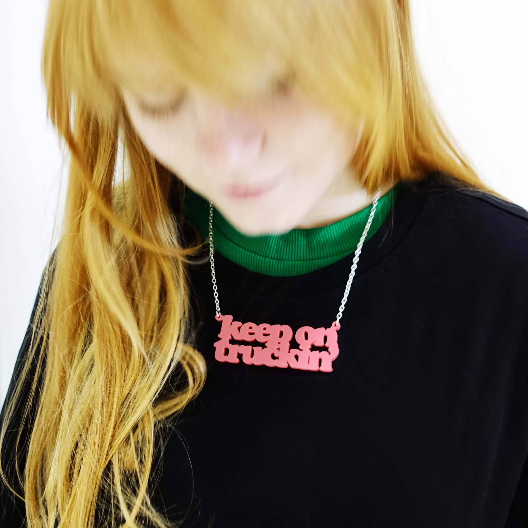 Eliza wears a Keep on Truckin' necklace in sunset pink, designed by Sarah Day for Wear and Resist. 