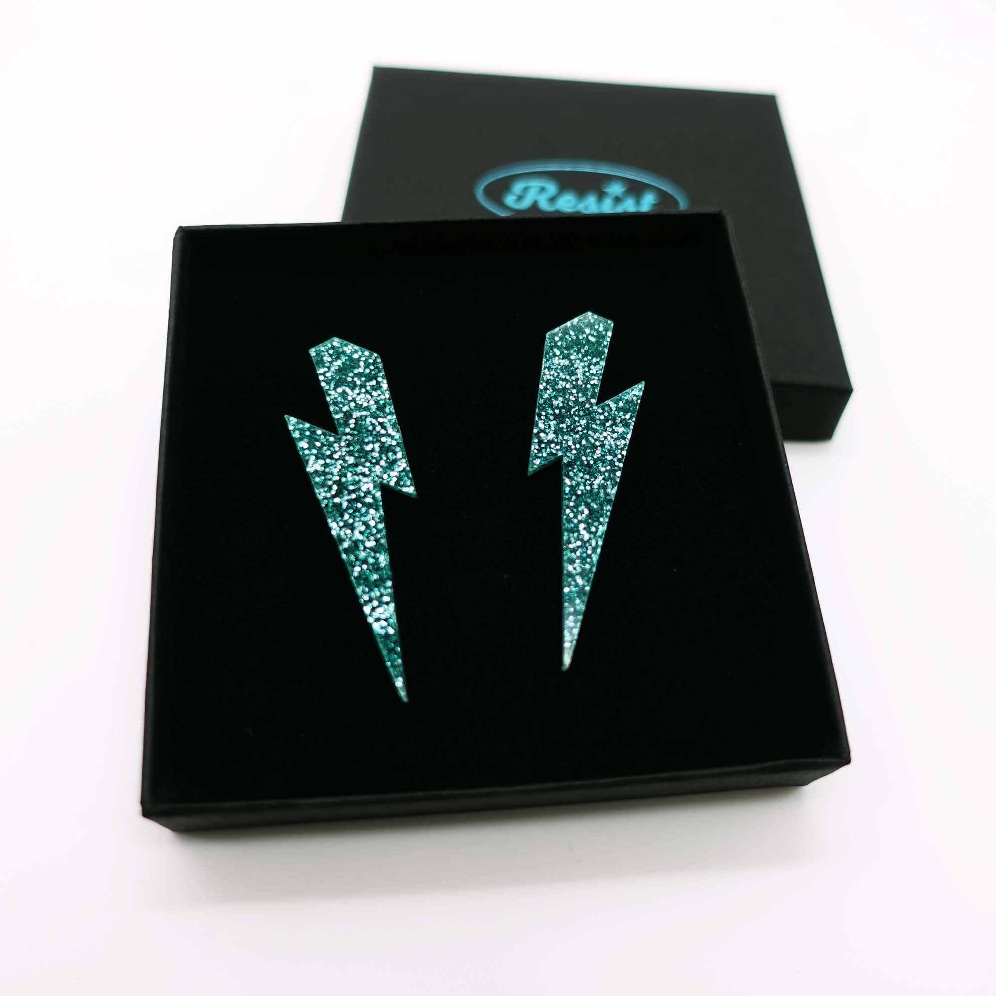 Teal glitter Lightning Bolt earrings designed by Sarah Day for Wear and Resist. 