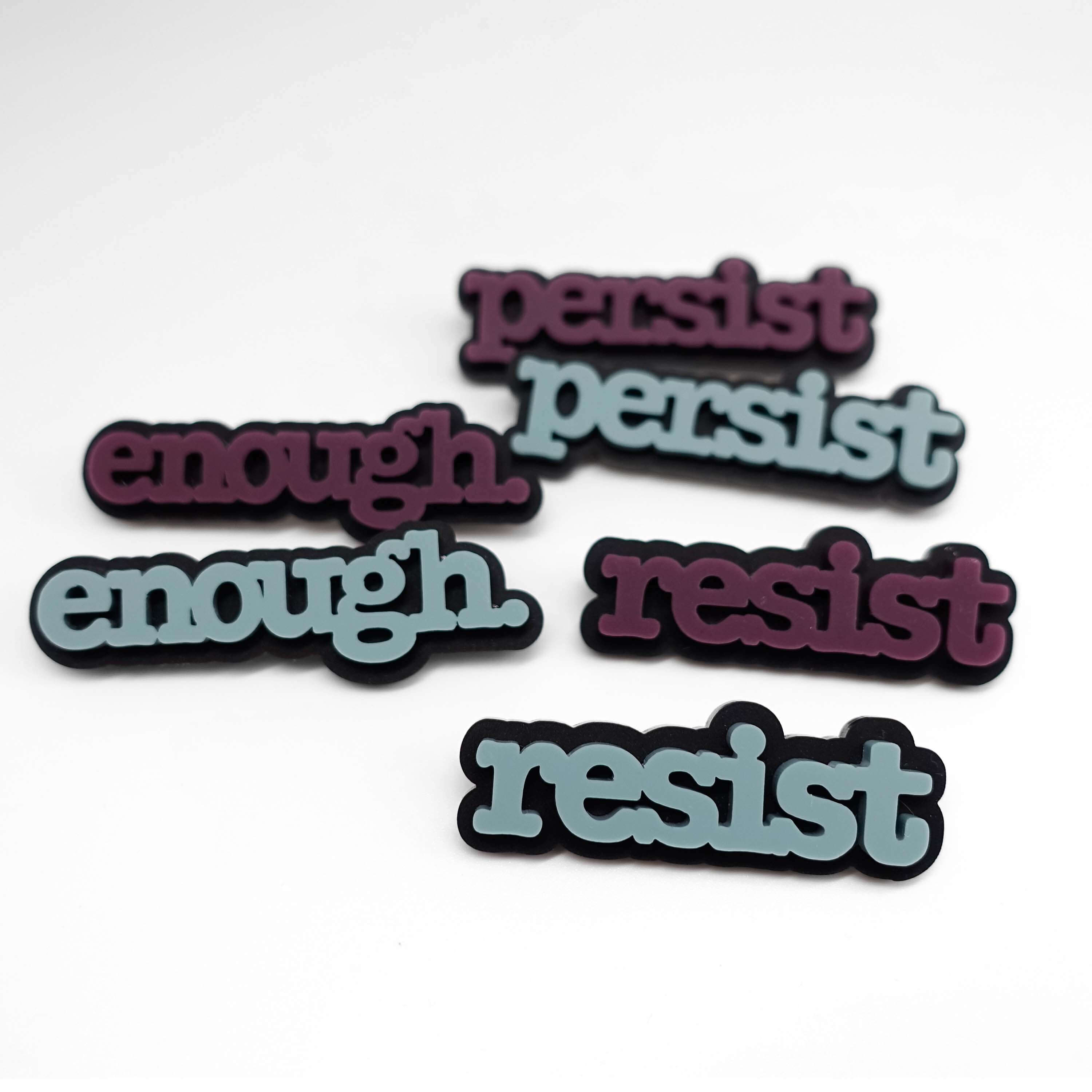 Typewriter brooches that say Resist, persist and enough in matte duck egg green and cassis