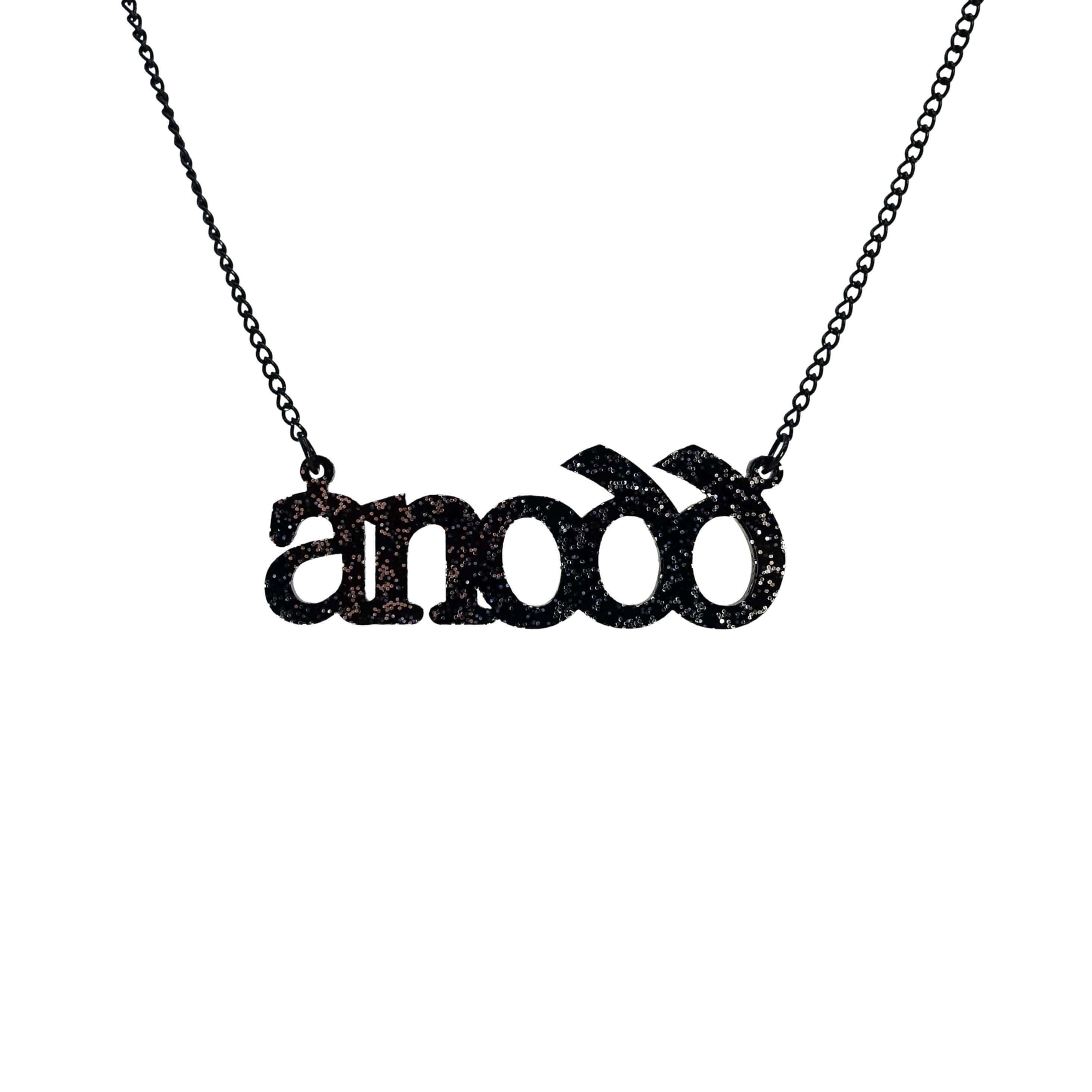 Anodd necklace for Welsh difficult women in black glitter, shown hanging on a stainless steel chain. 