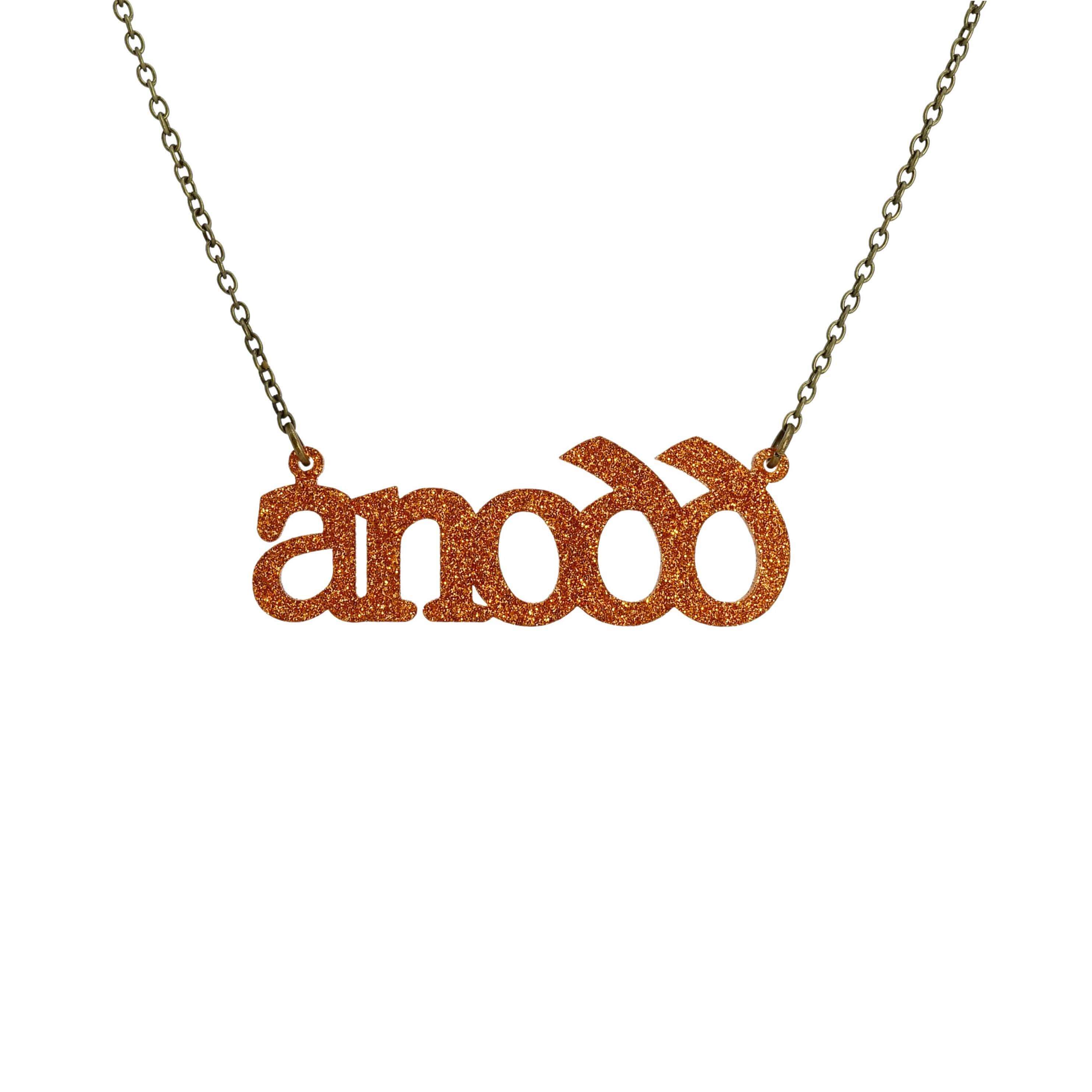 Anodd necklace for Welsh difficult women in burnt orange glitter, shown hanging on a stainless steel chain. 