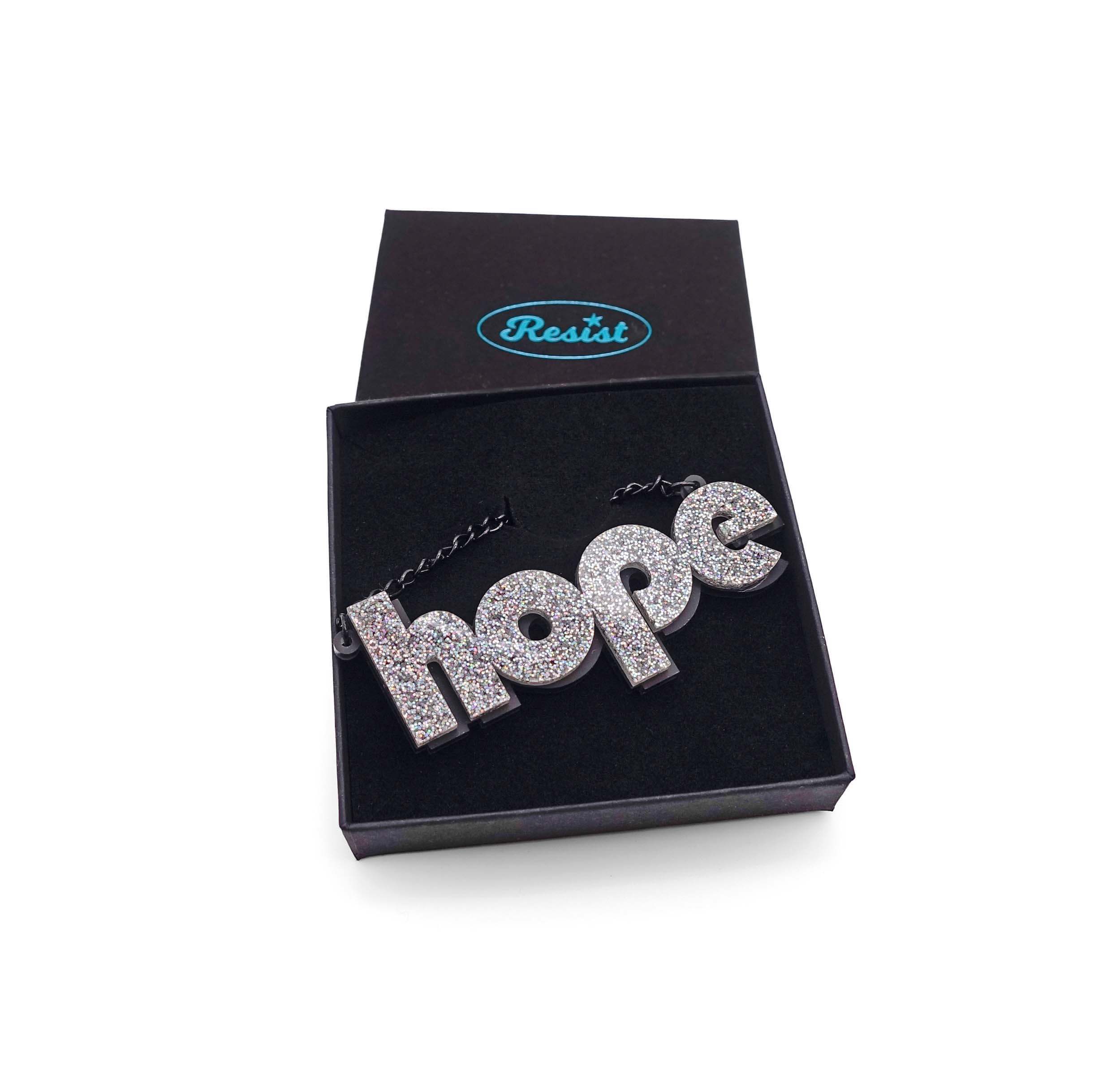 Hope statement necklace in silver glitter, shown in a Wear and Resist gift box.