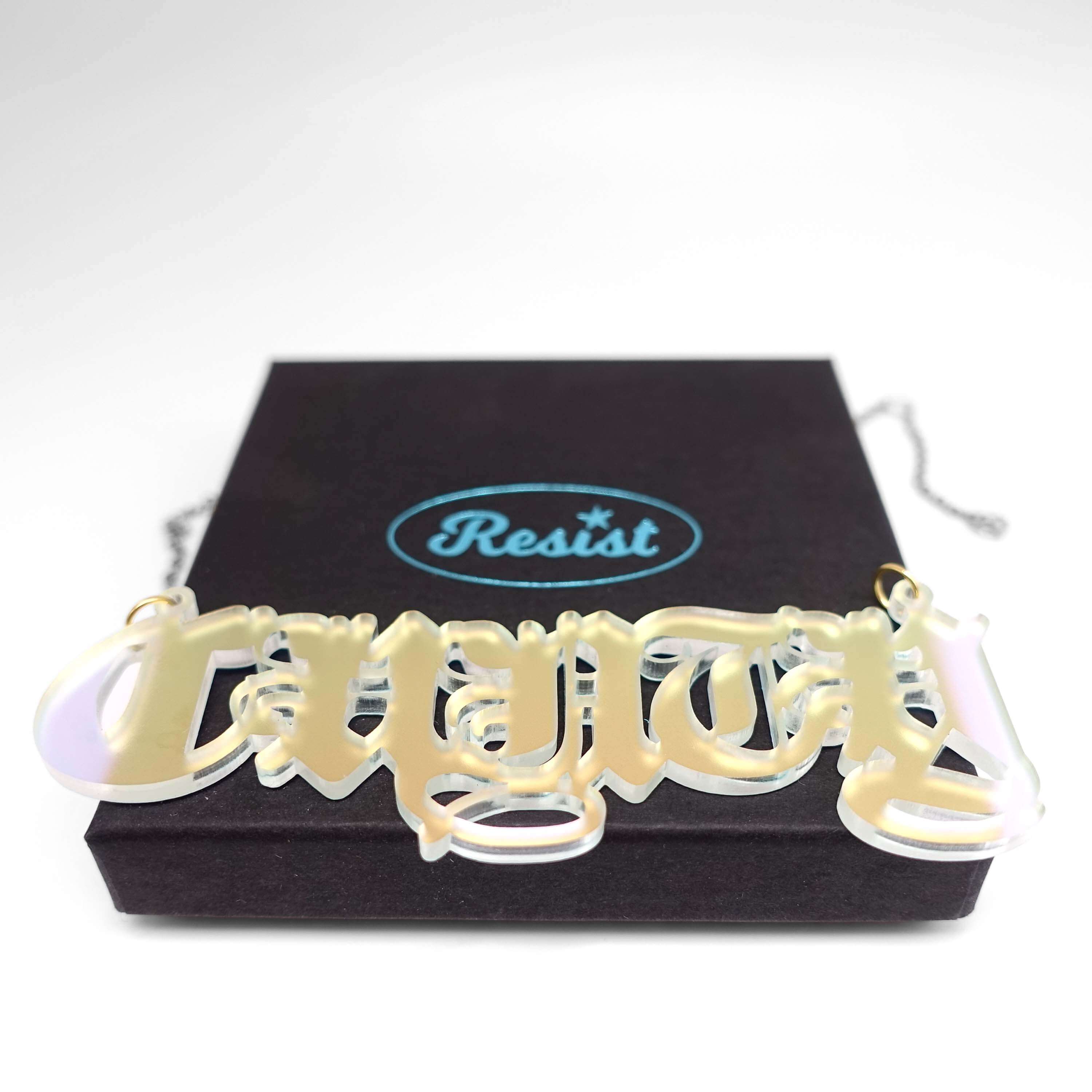 Big C*nty necklace in matte iridescent shown on a Wear & Resist gift box.  