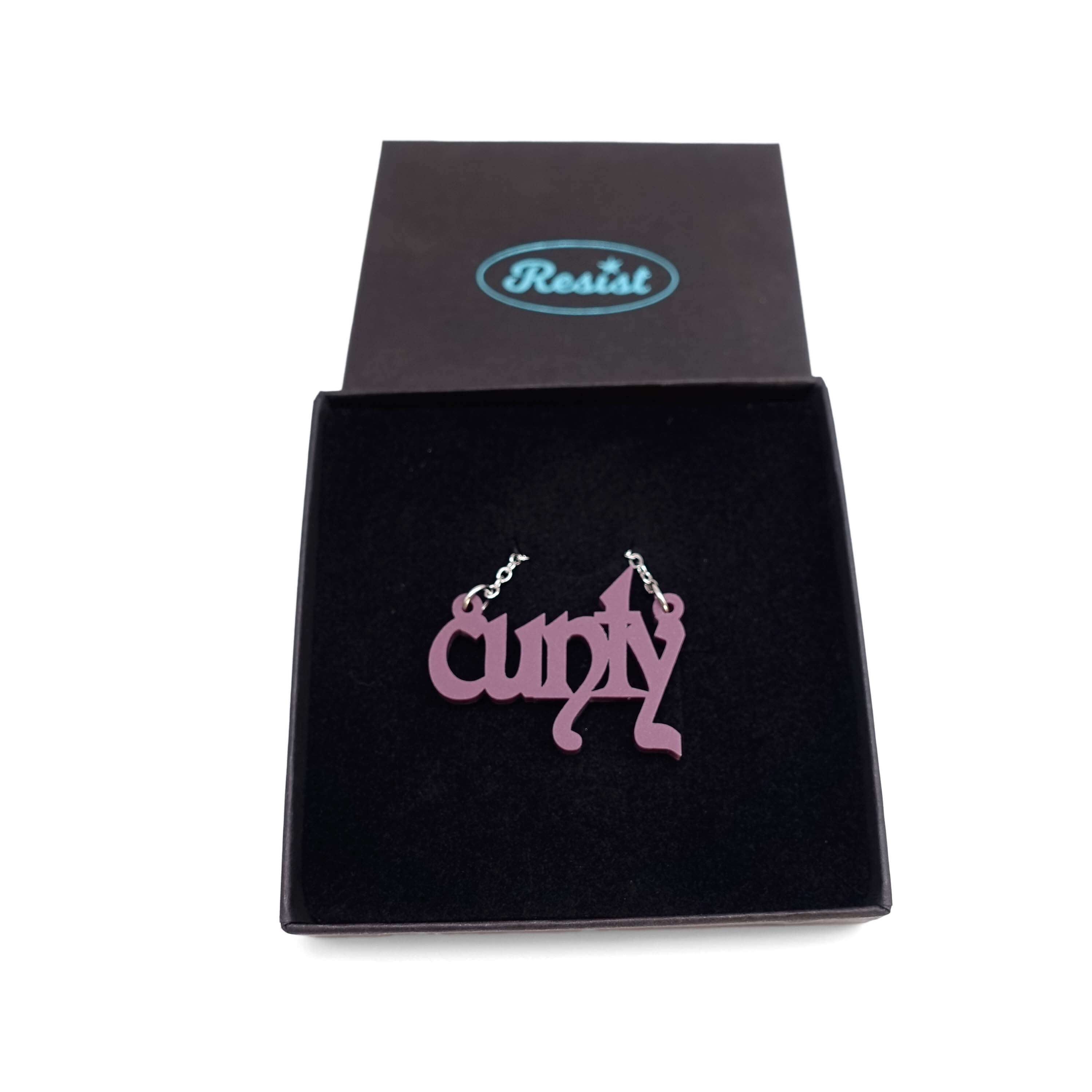 Little CUNTY necklace in matte cassis shown in a Wear & Resist gift box. 