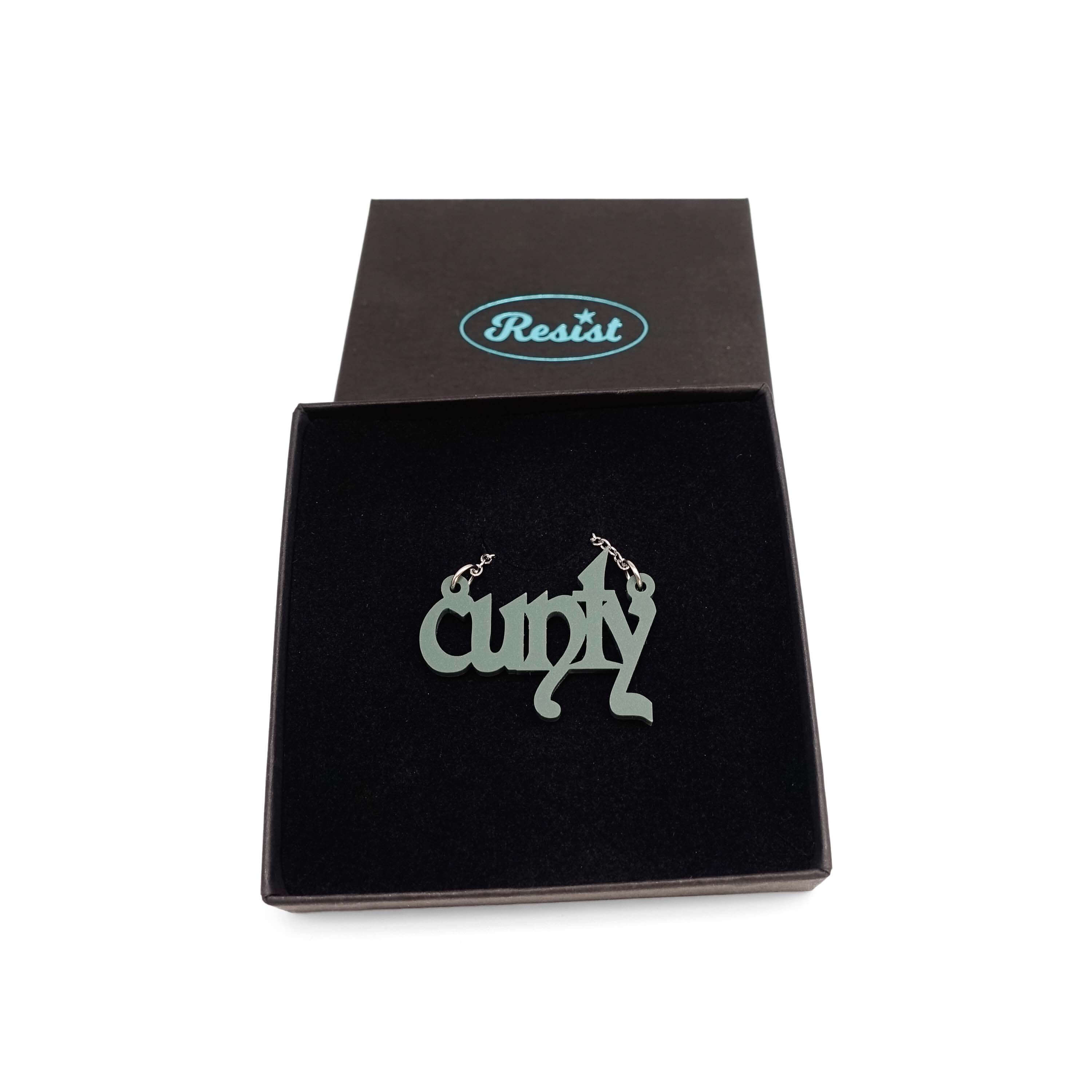 Little CUNTY necklace in matte moss shown in a Wear & Resist gift box. 