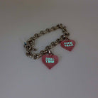 Stainless steel charm bracelet with pale pink Hell Yes and F*ck Yeah heart charms glowing in the dark. 