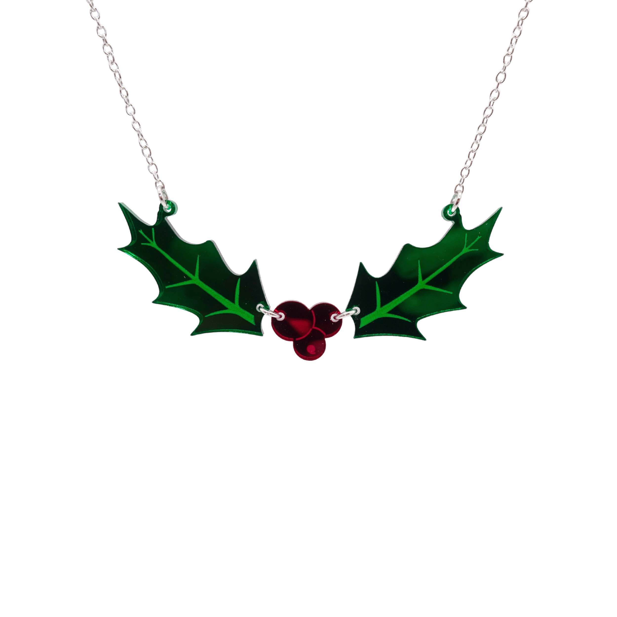 Holly necklace hanging on a silver chain against a white background. 