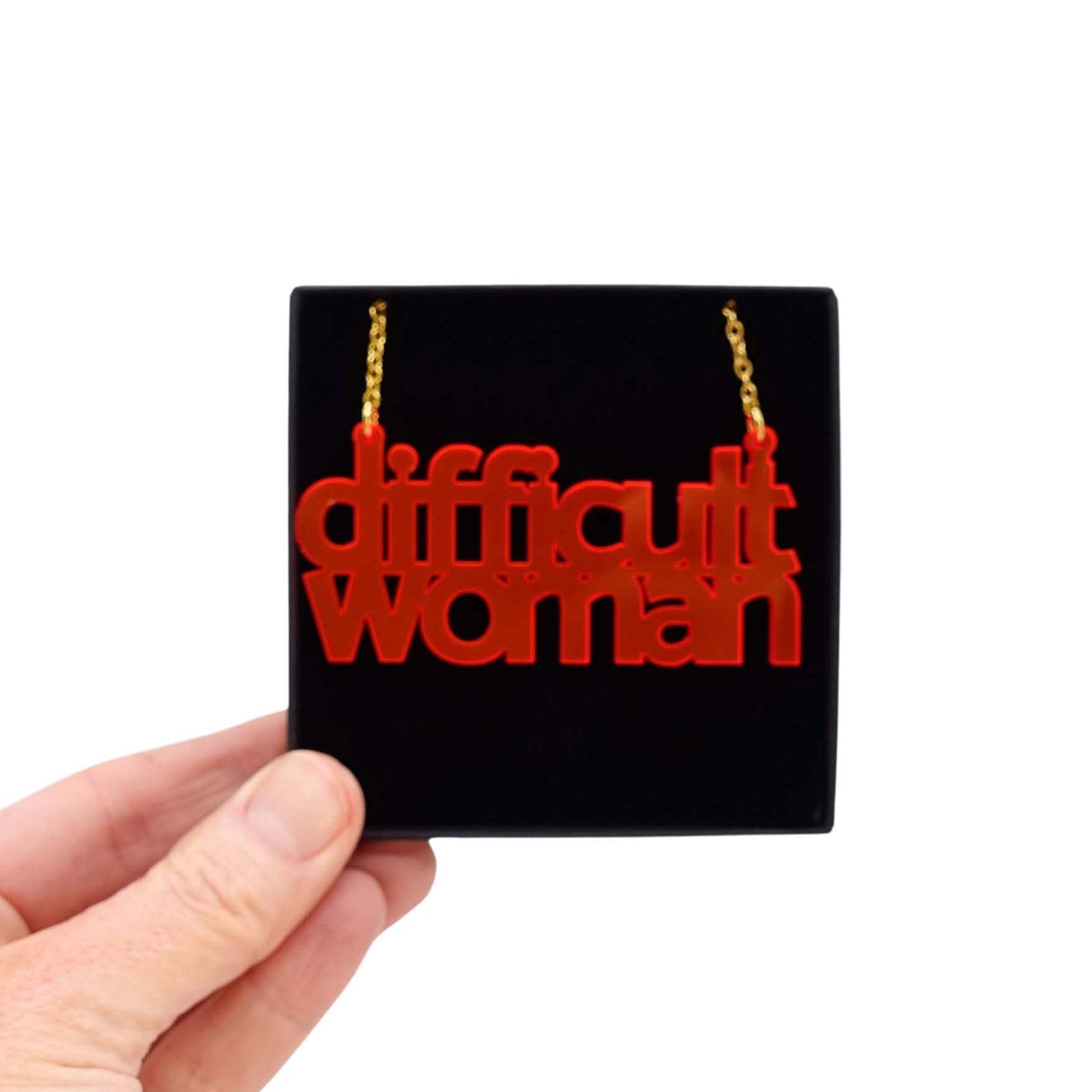 Difficult Woman necklace in hot red, shown held up in a Wear and Resist gift box. 