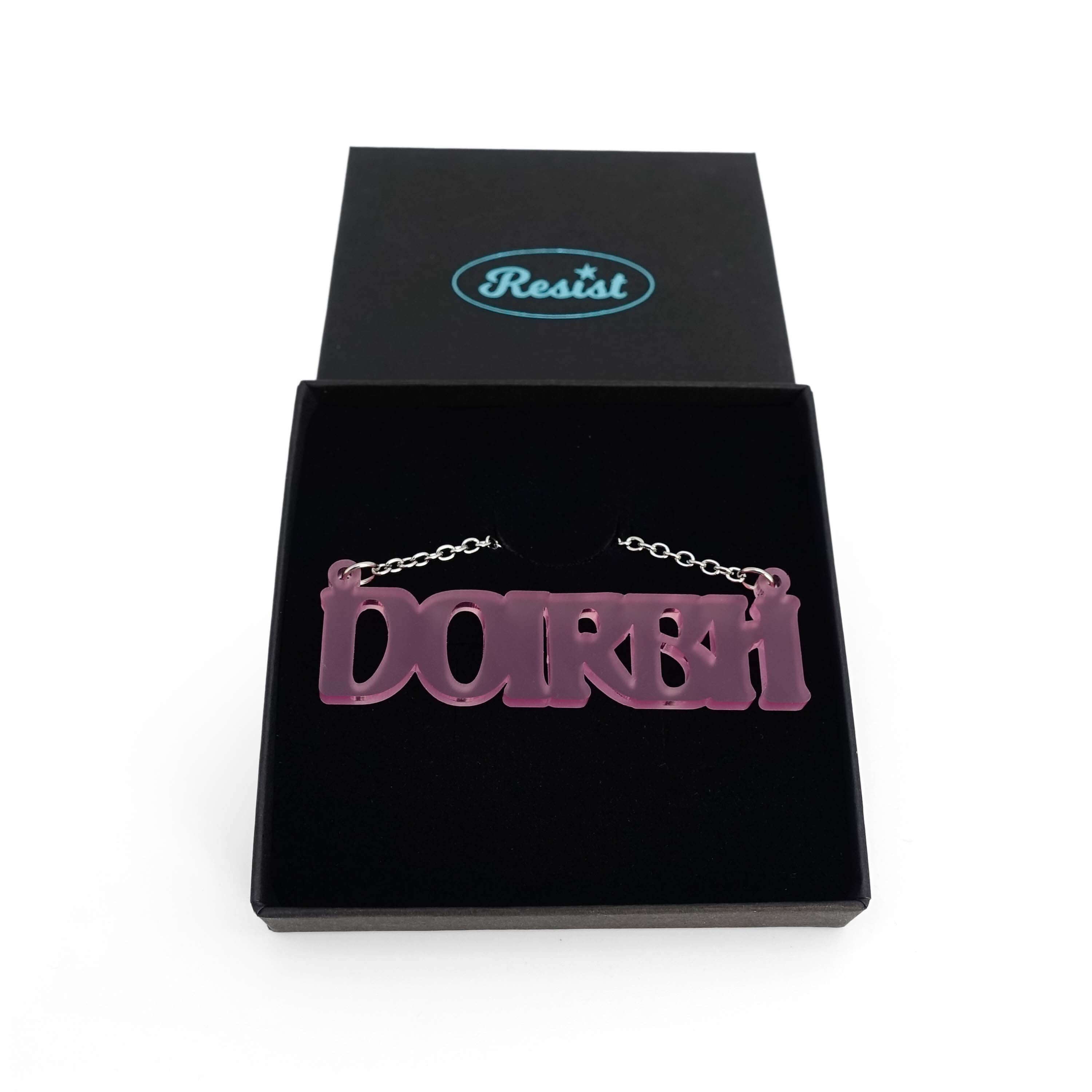 DOIRBH Gaelige necklace for Irish difficult women in pink frost, shown in a Wear & Resist gift box. 
