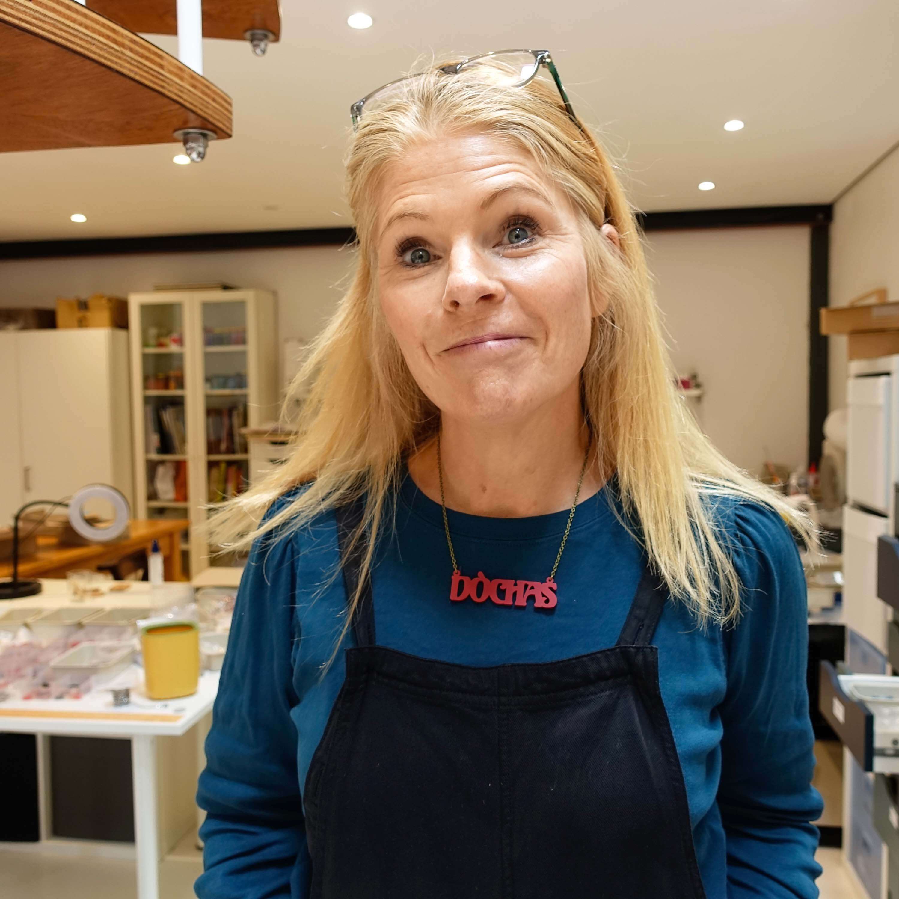 Sarah wears an oxblood red DÒCHAS Irish Gaelige hope necklace in her studio. 