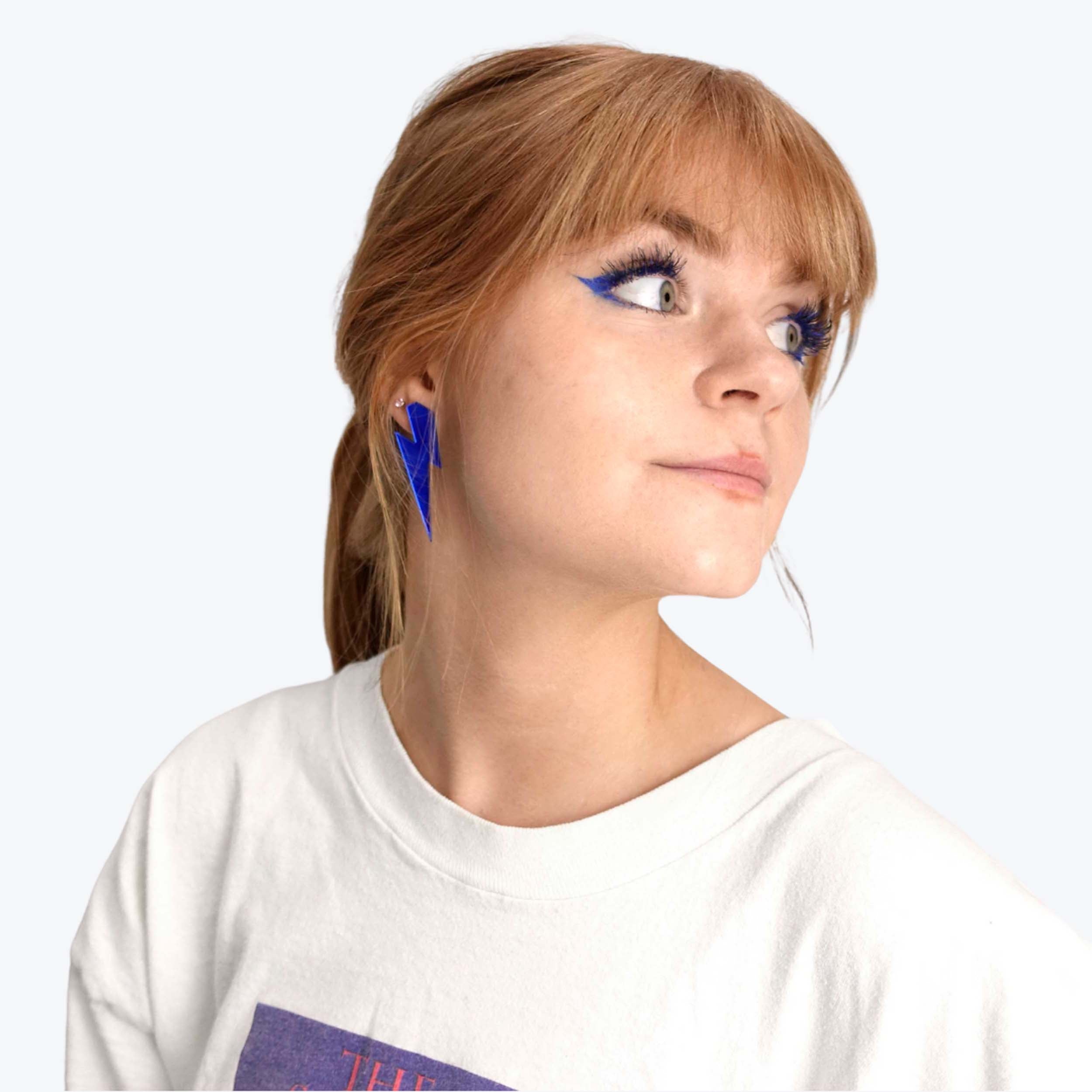Eliza wears electric blue Lightning Bolt earrings designed by Sarah Day for Wear and Resist. 