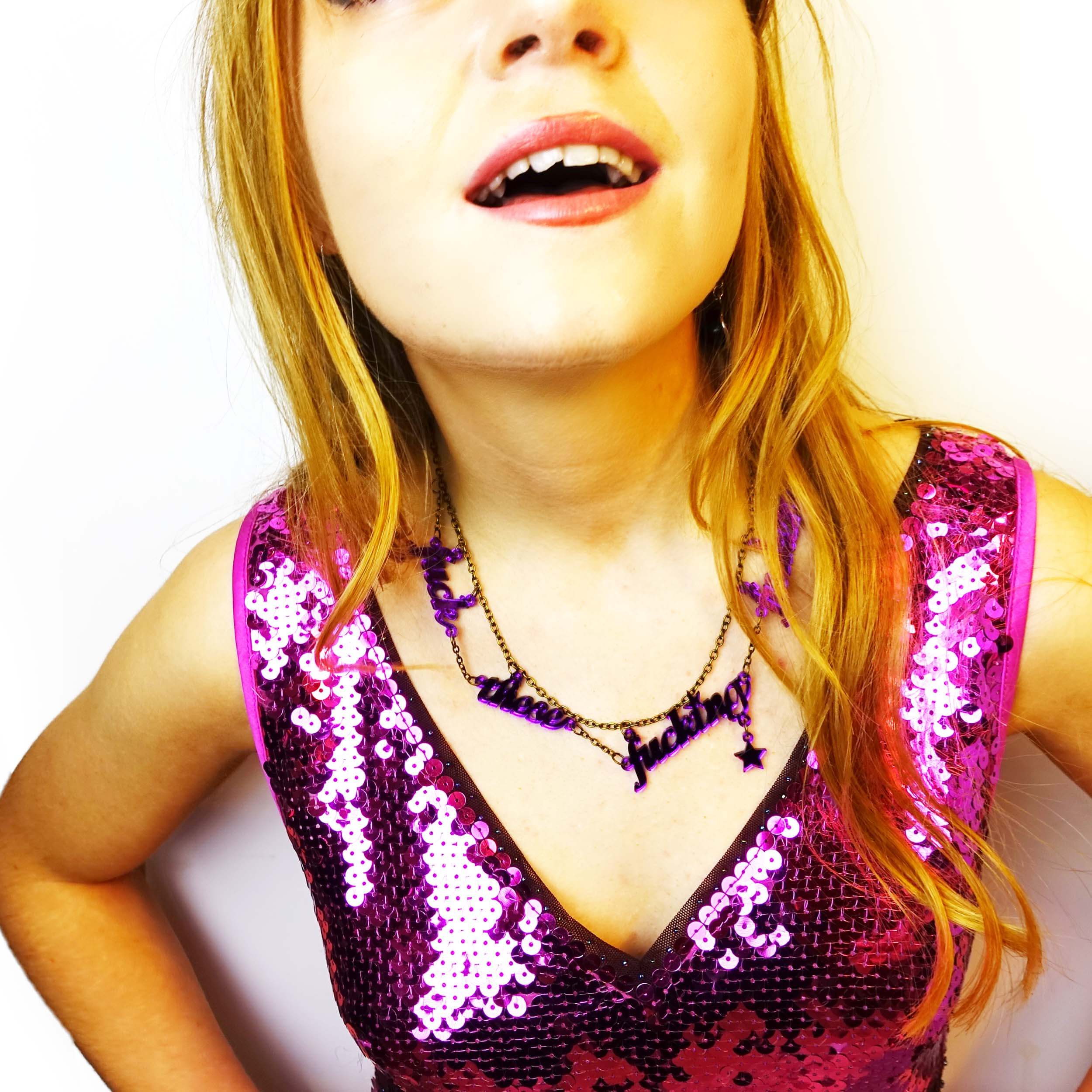 Model wears F*ck These F*cking F*ckers necklace in Poison lies Purple designed by Sarah Day the founder of Wear and Resist. 