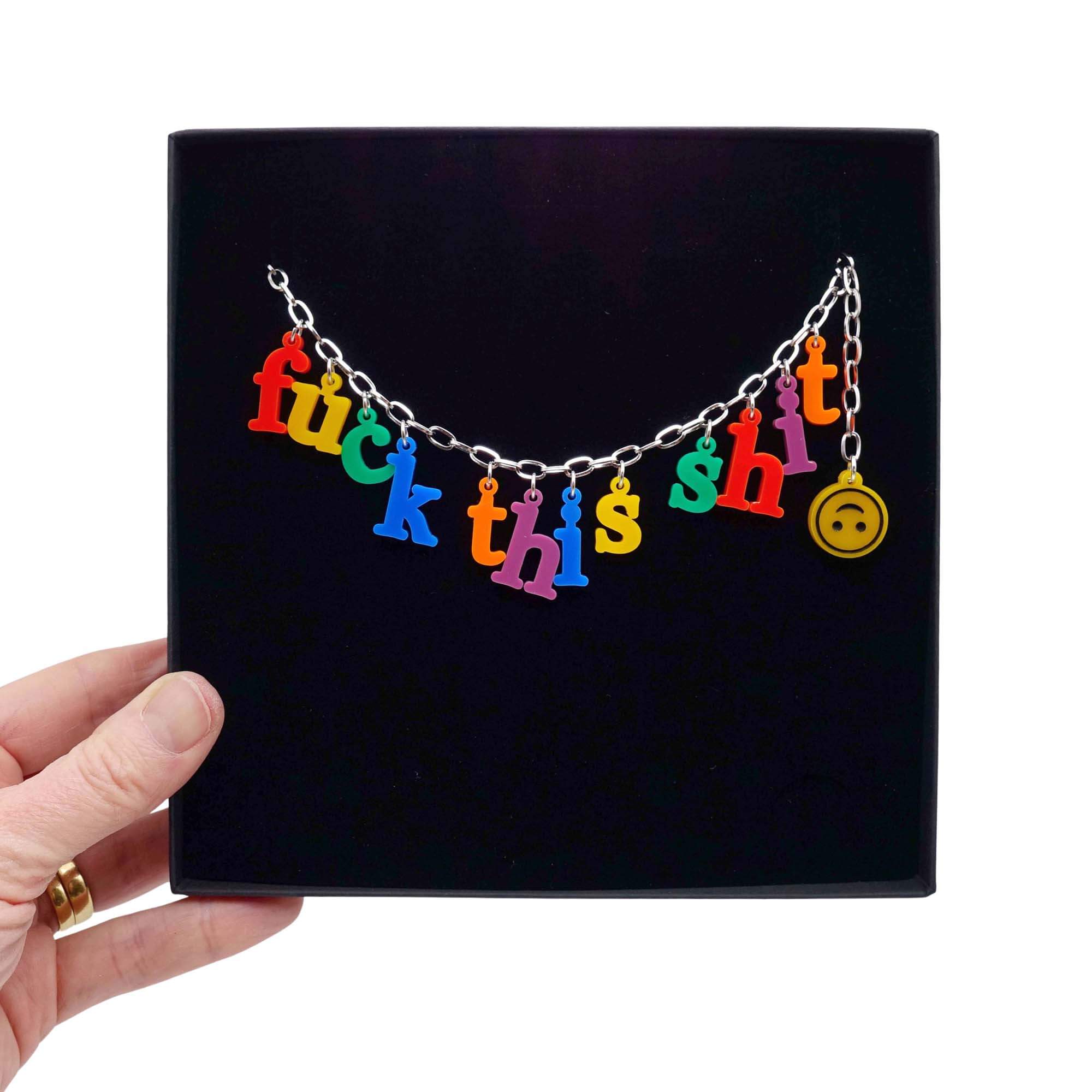 F*ck this Sh*t Alphabet necklace with colourful sweary letters and an upside down smiley face emoji! Swearing is caring, folks. £2 goes to Bloody Good Period. Shown held up in a large Wear and Resist gift box. 