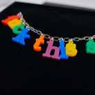 A close up of the F*ck this Sh*t Alphabet necklace with colourful sweary letters reminiscent of fridge magnets. 